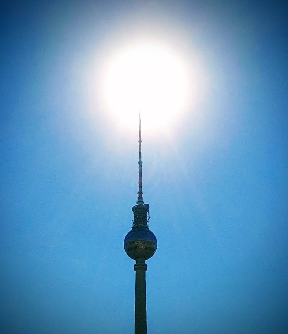 Berlin, the sun is right behind the top of the tower.