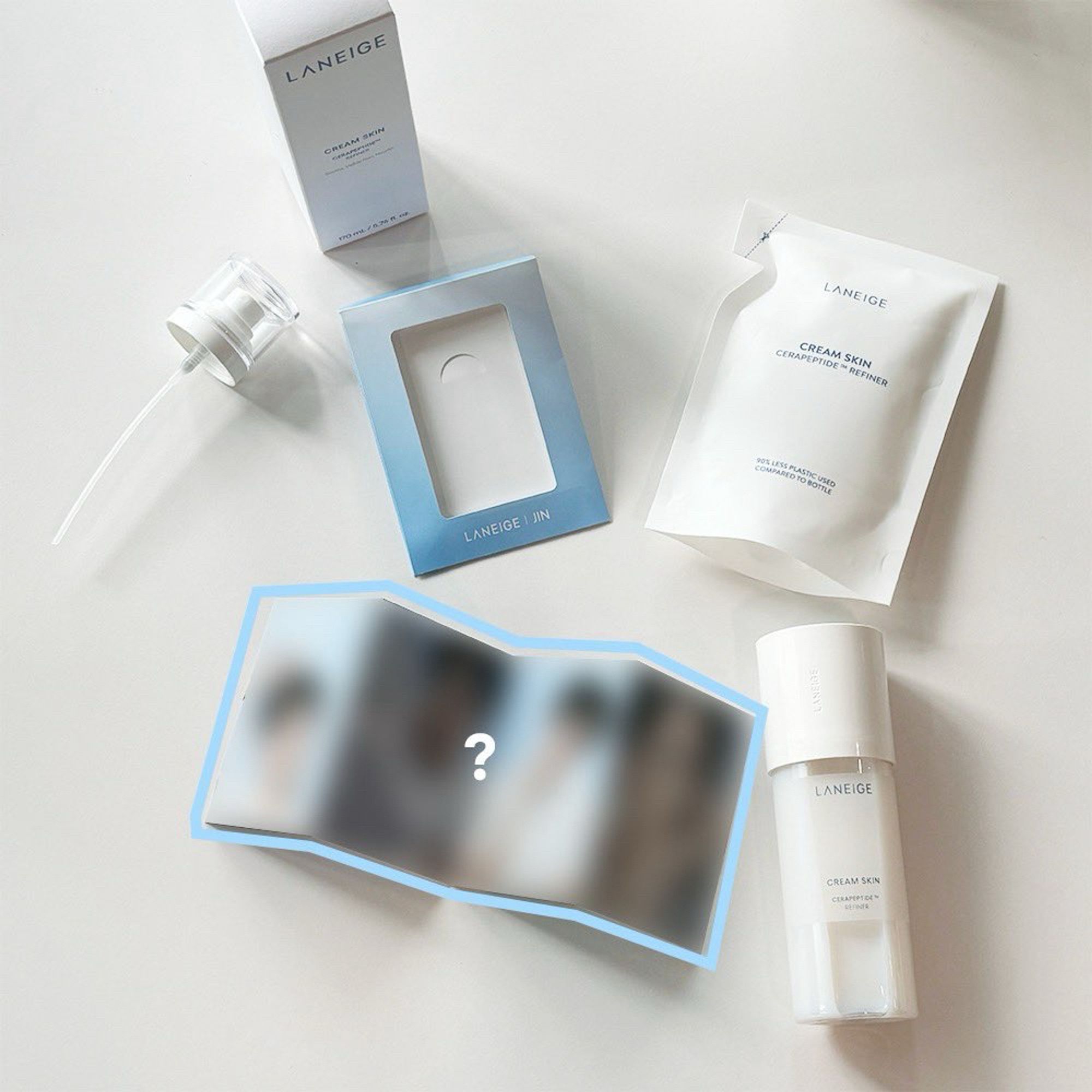 Laneige items with a mini photobook open next yo yhem. The photos in tthe pb are blurred.