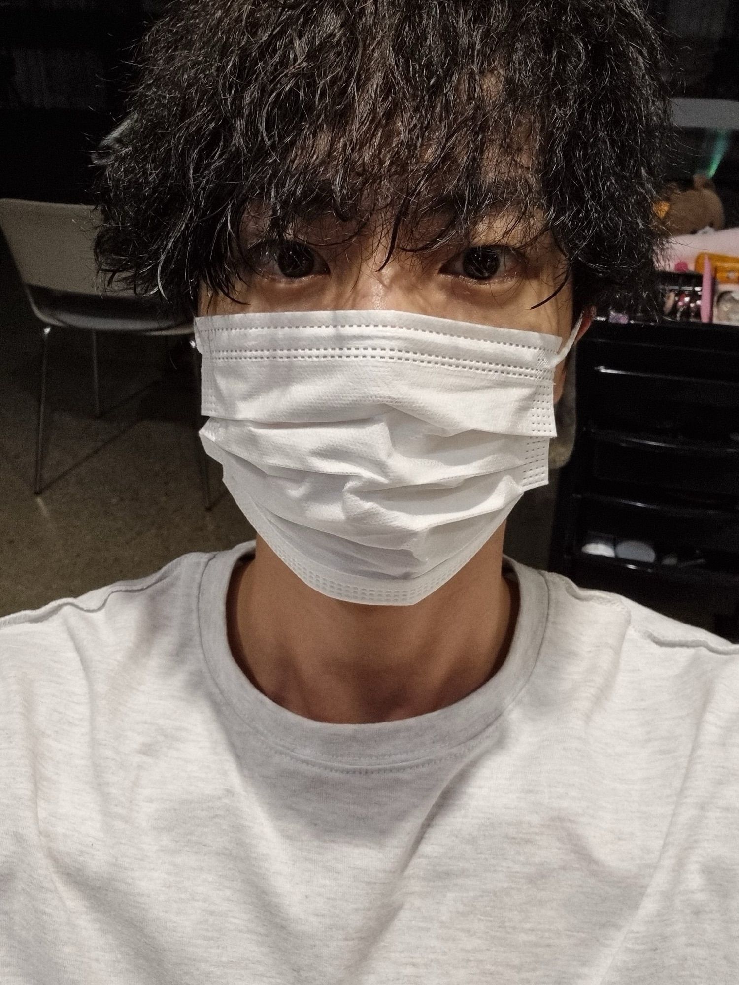 Seokiin in light gray shirt and facemask sporting his newly permed hair