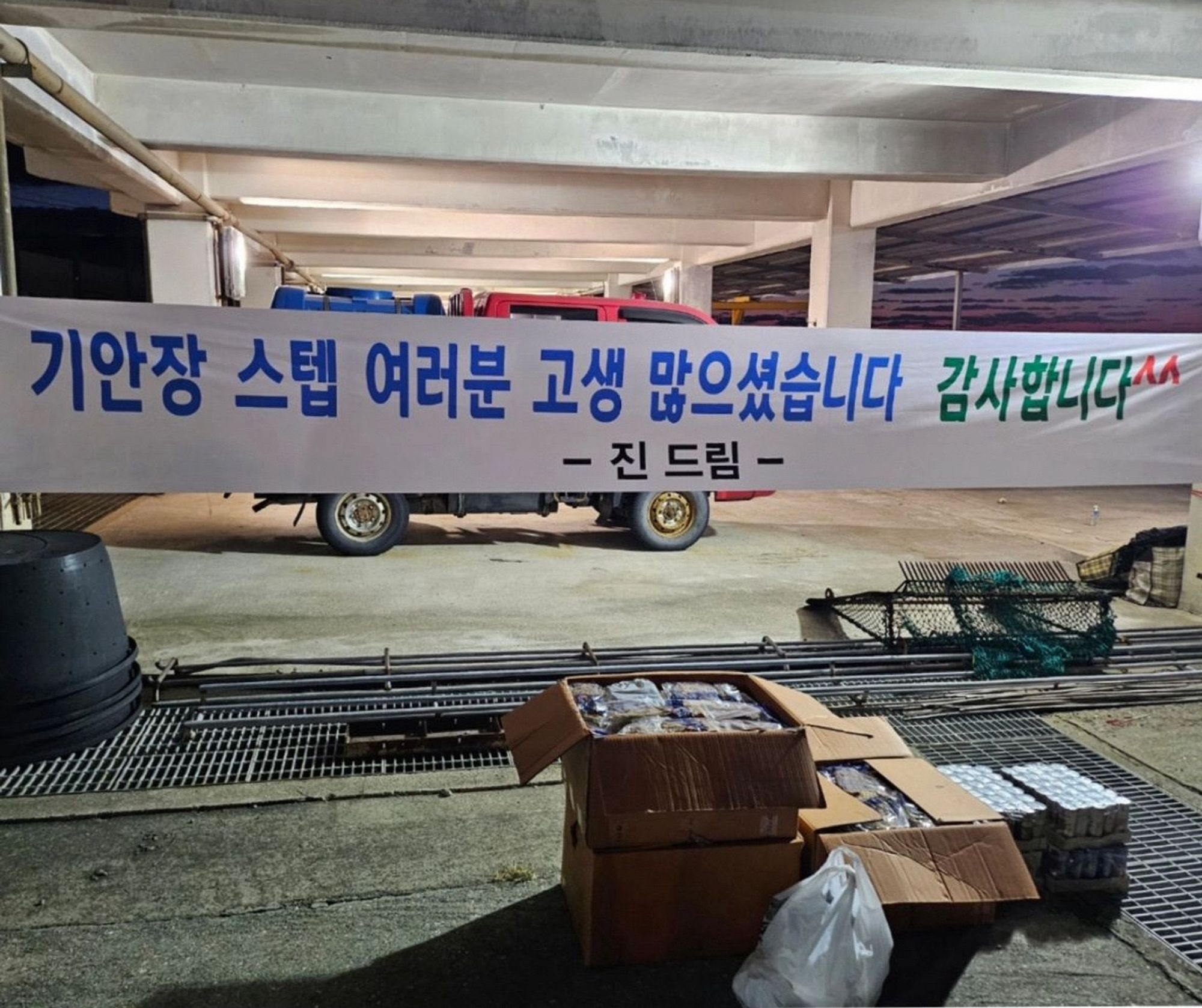 Boxes of packed food and drinks beneath a banner that says: "To the staff of 'KIAN's Bizarre B&B' you've worked hard. Thank you^^ -From Jin"