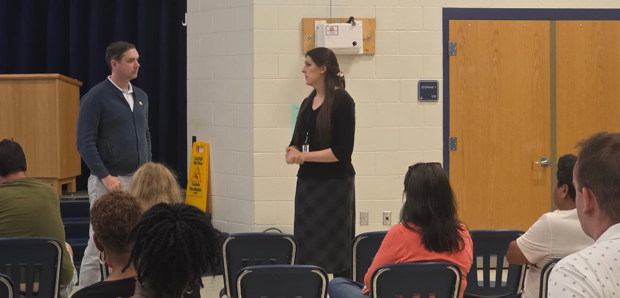 Delegate Josh Thomas and Senator Danica Roem talk about the presentation while their constituents are seated in front of them.