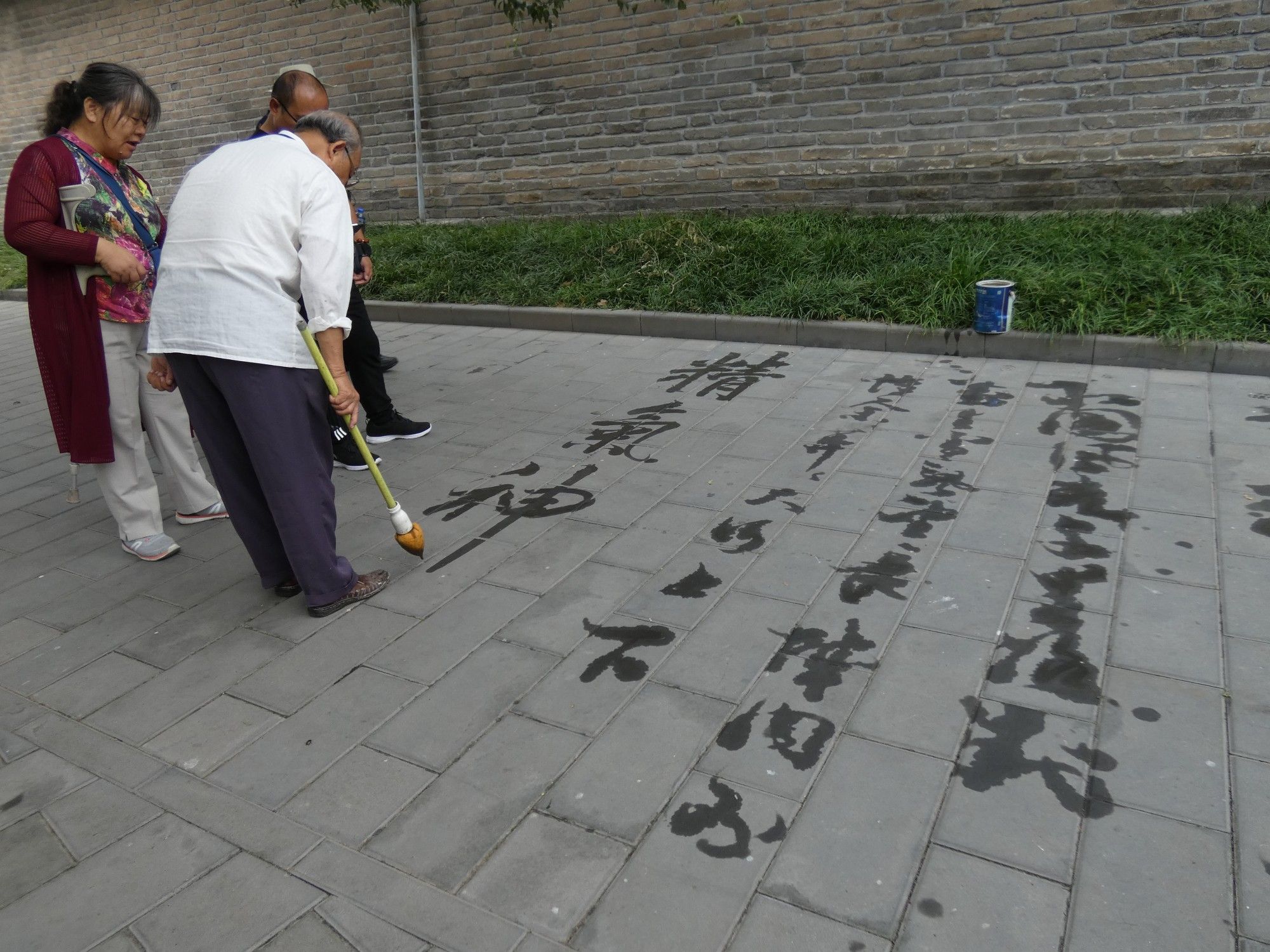 practicing calligraphy with water on pavement