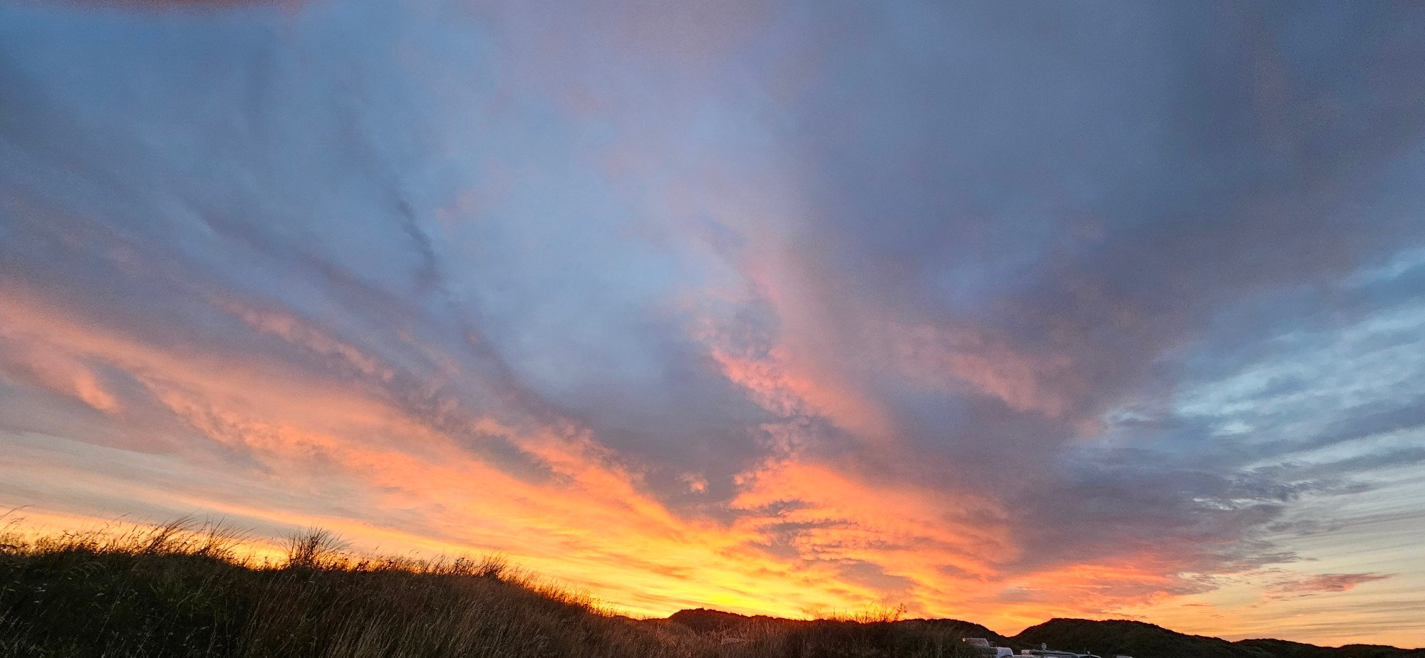 Sonnenuntergang an der Nordsee. Wolken werden Orange angestrahlt