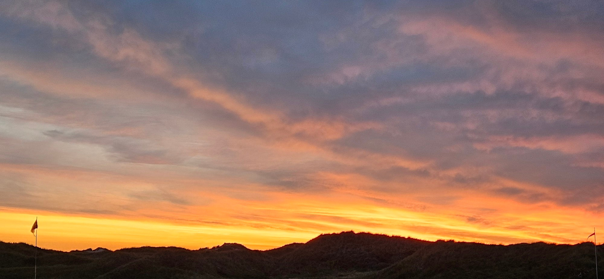 Sonnenuntergang an der Nordsee. Wolken werden Orange angestrahlt