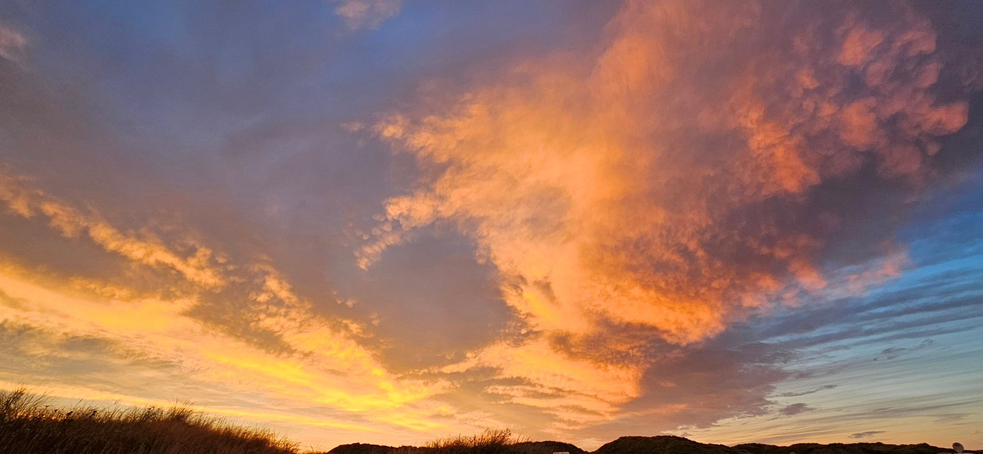 Sonnenuntergang an der Nordsee. Wolken werden Orange angestrahlt