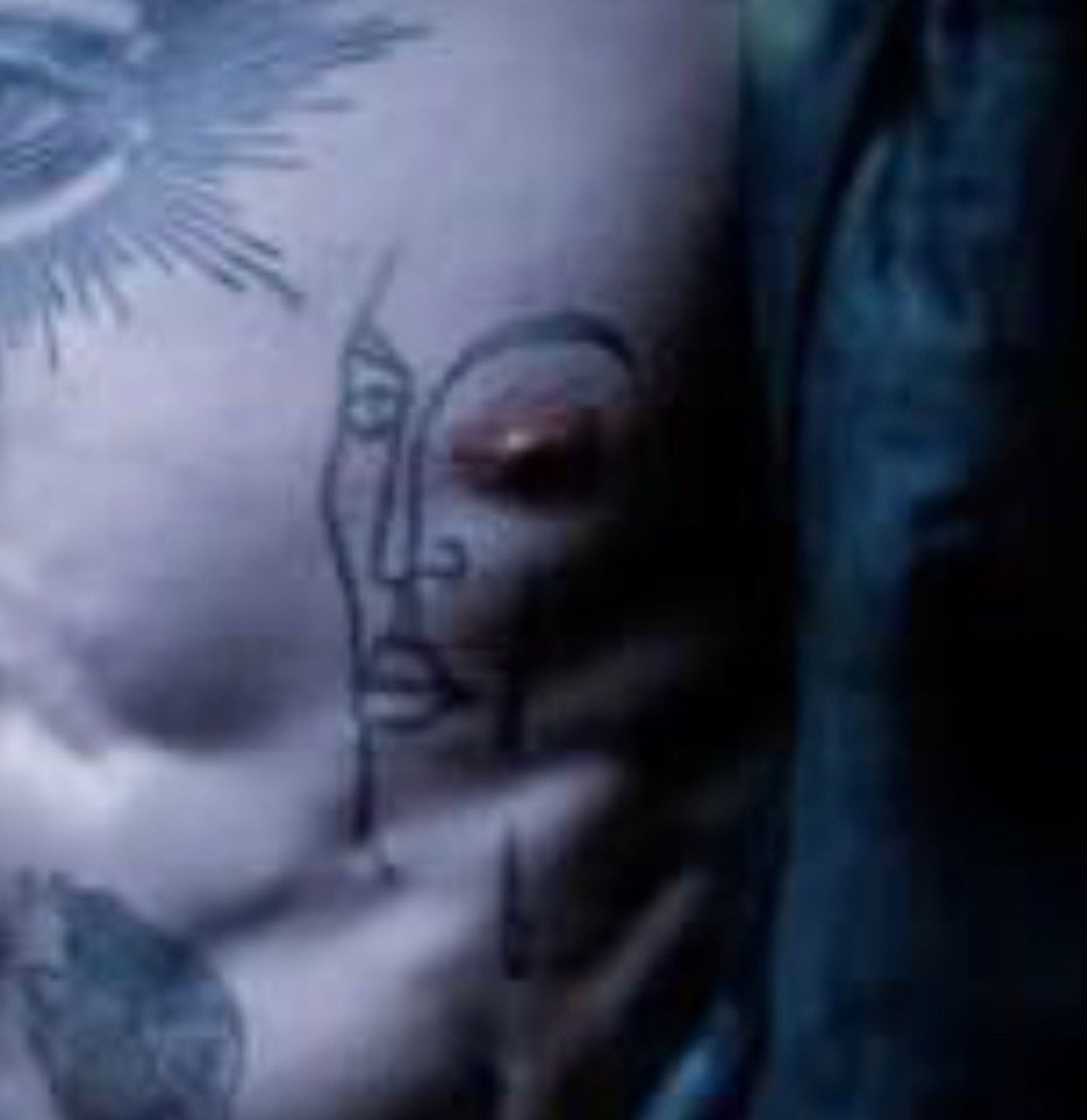 A close-up on one specific tattoo, depicting a face with the actor’s nipple appearing as its eye