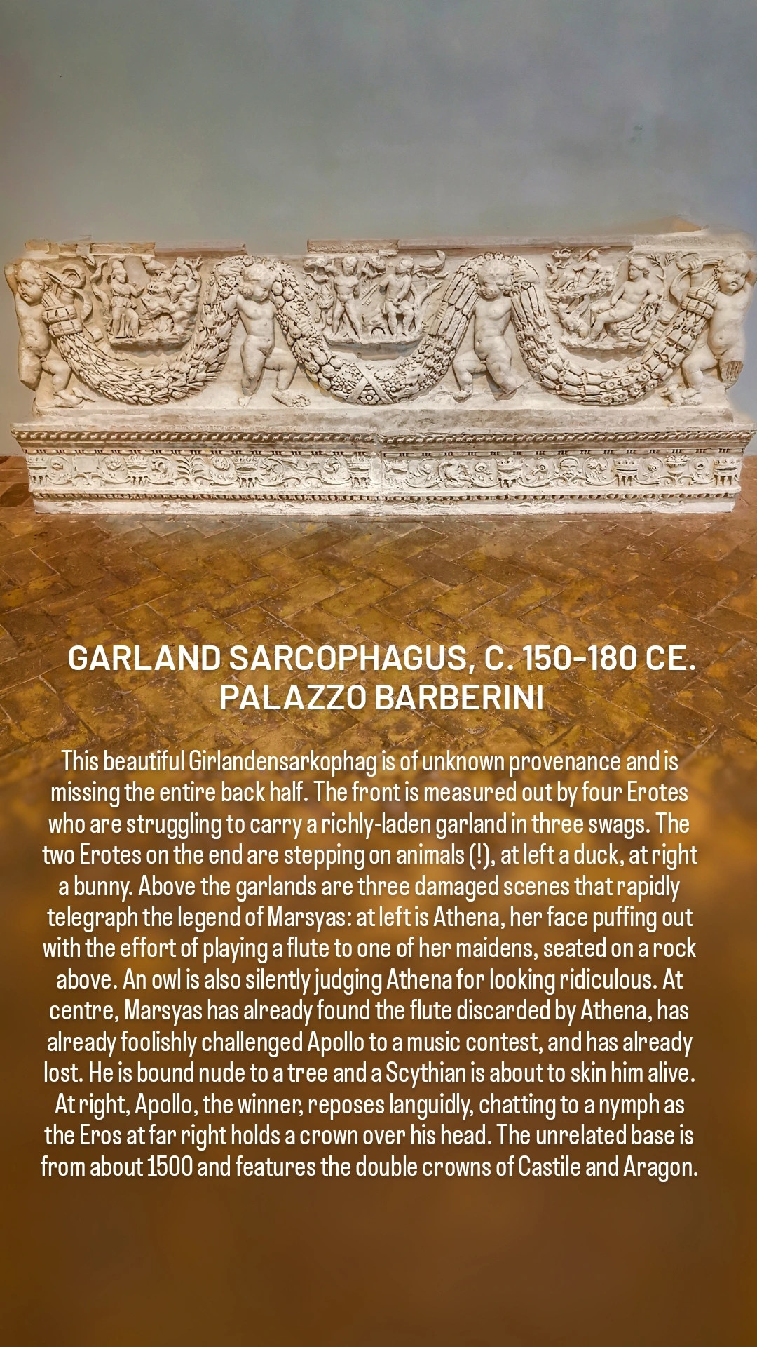 GARLAND SARCOPHAGUS, C. 150-180 CE. PALAZZO BARBERINI

This beautiful Girlandensarkophag is of unknown provenance and is missing the entire back half. The front is measured out by four Erotes who are struggling to carry a richly-laden garland in three swags. The two Erotes on the end are stepping on animals (!), at left a duck, at right a bunny. Above the garlands are three damaged scenes that rapidly telegraph the legend of Marsyas: at left is Athena, her face puffing out with the effort of playing a flute to one of her maidens, seated on a rock above. An owl is also silently judging Athena for looking ridiculous. At centre, Marsyas has already found the flute discarded by Athena, has already foolishly challenged Apollo to a music contest, and has already lost. He is bound nude to a tree and a Scythian is about to skin him alive. At right, Apollo, the winner, reposes languidly, chatting to a nymph as the Eros at far right holds a crown over his head. The unrelated base is from about 1500 and features the double crowns of Castile and Aragon.