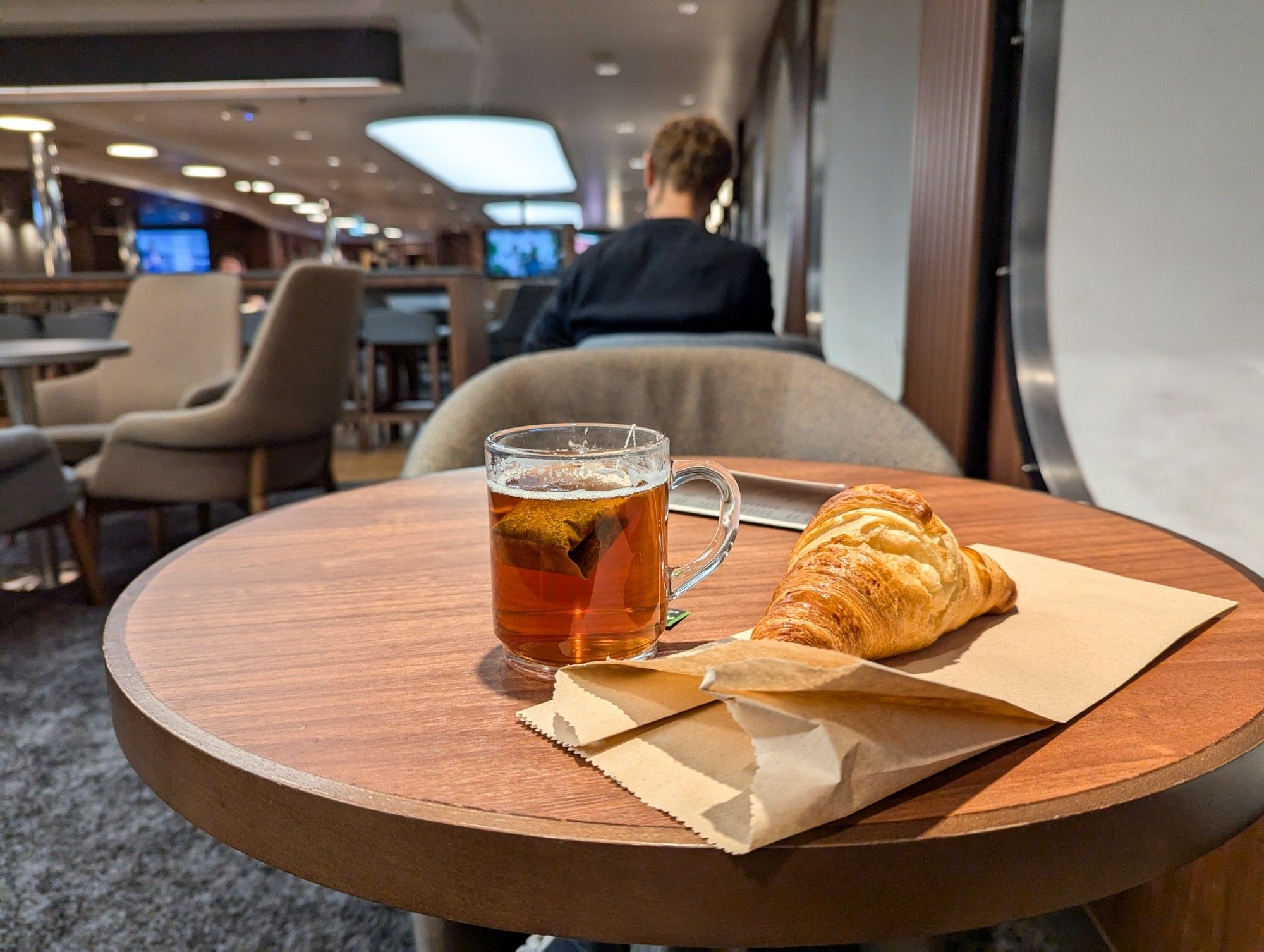 Tea and croissant on a table at the bar.