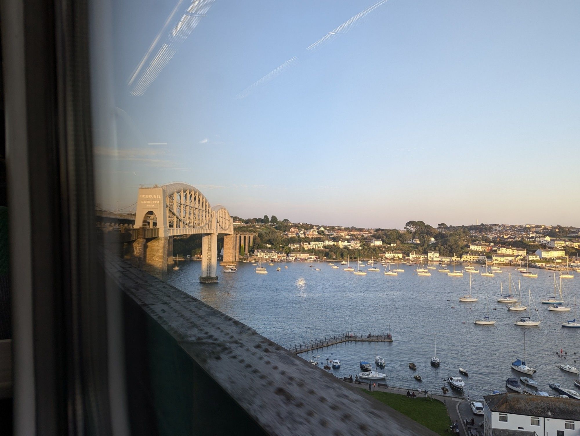 View through the train window: The line curves away from the huge, historic steel bridge over the  River Tamar