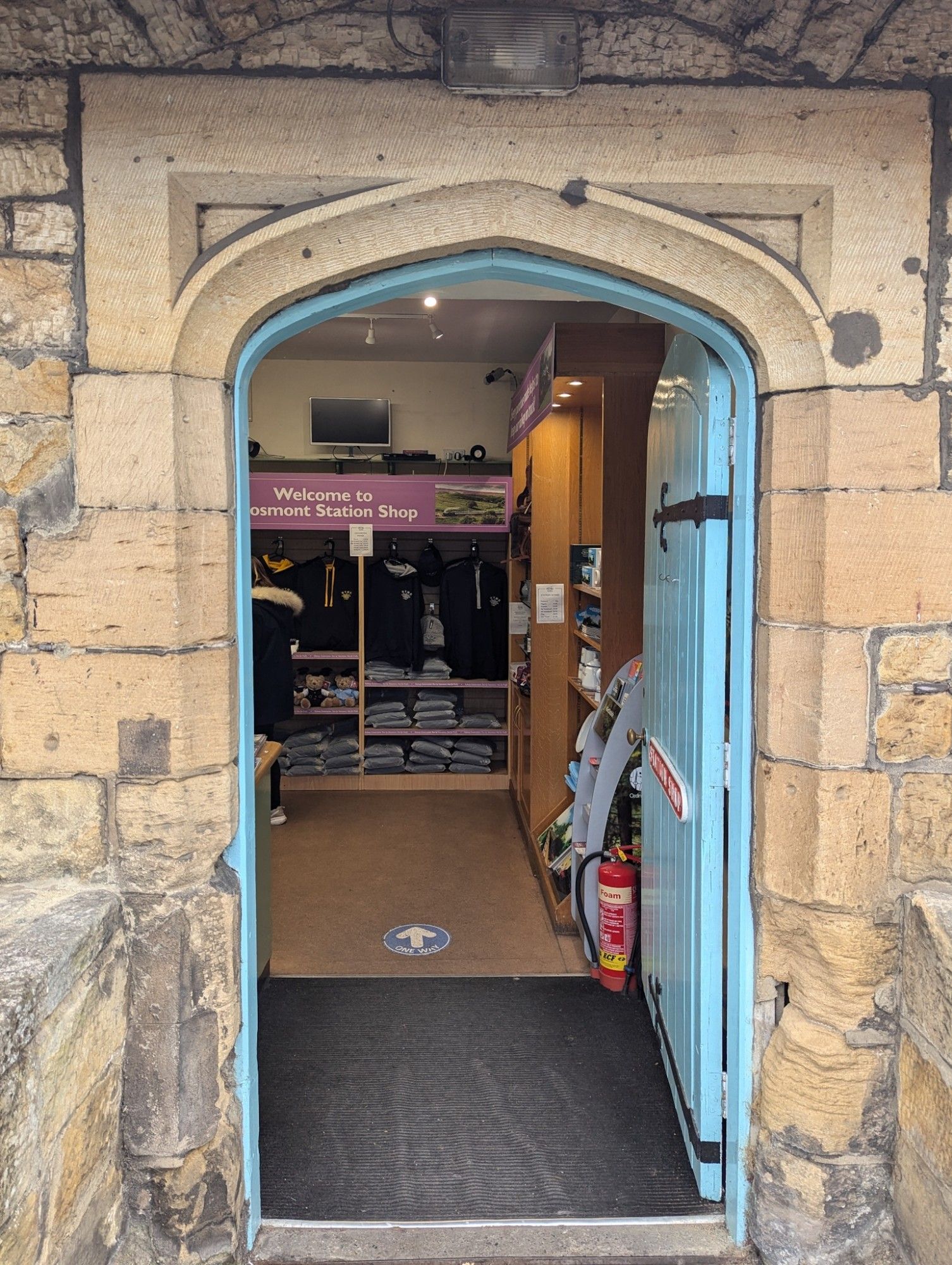 Old door forms the entrance to the shop. Inside, NYMR merch clothes.