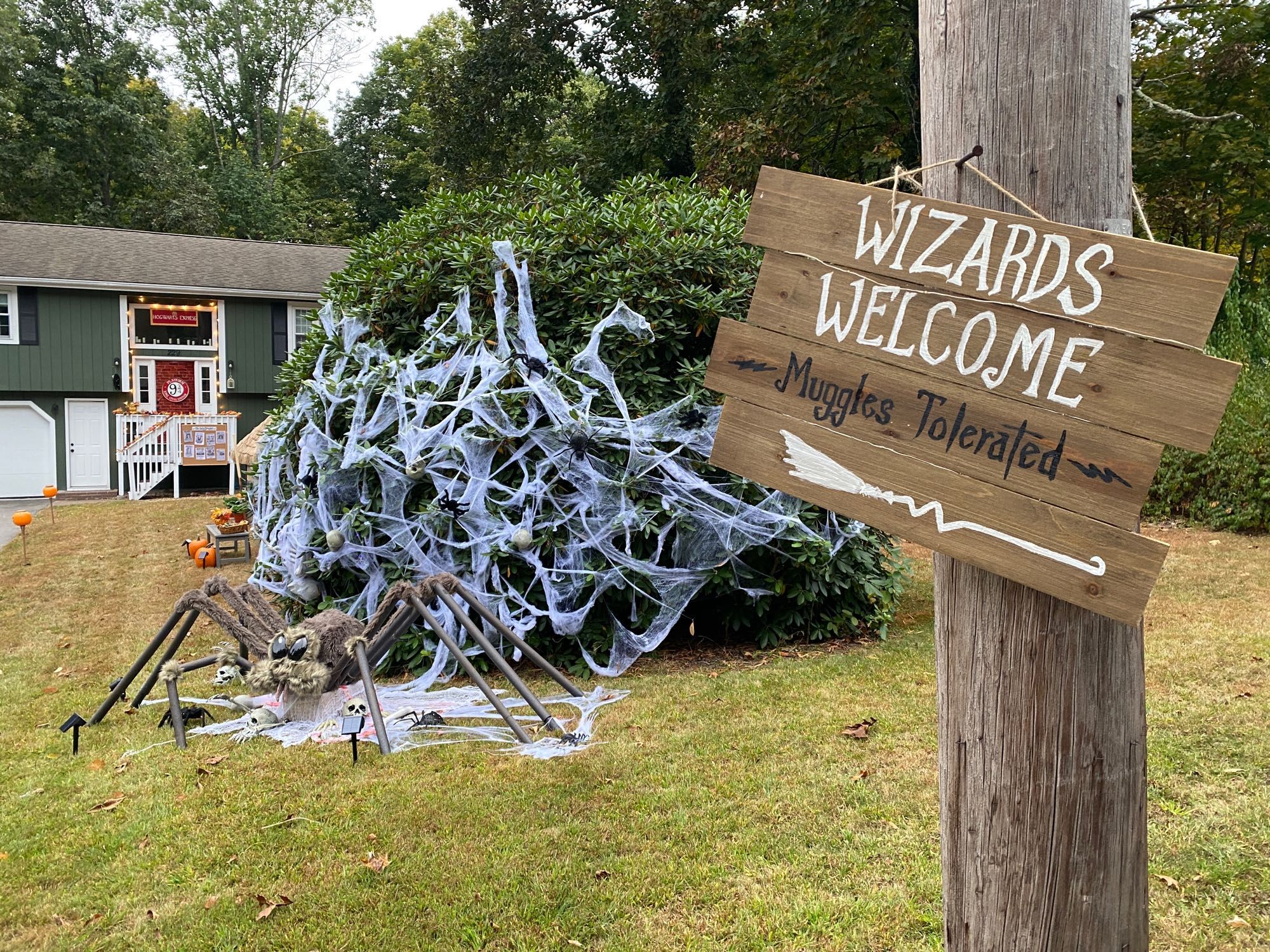 A Harry Potter styled Halloween decoration with a giant spider and a sign reading Wizards welcome