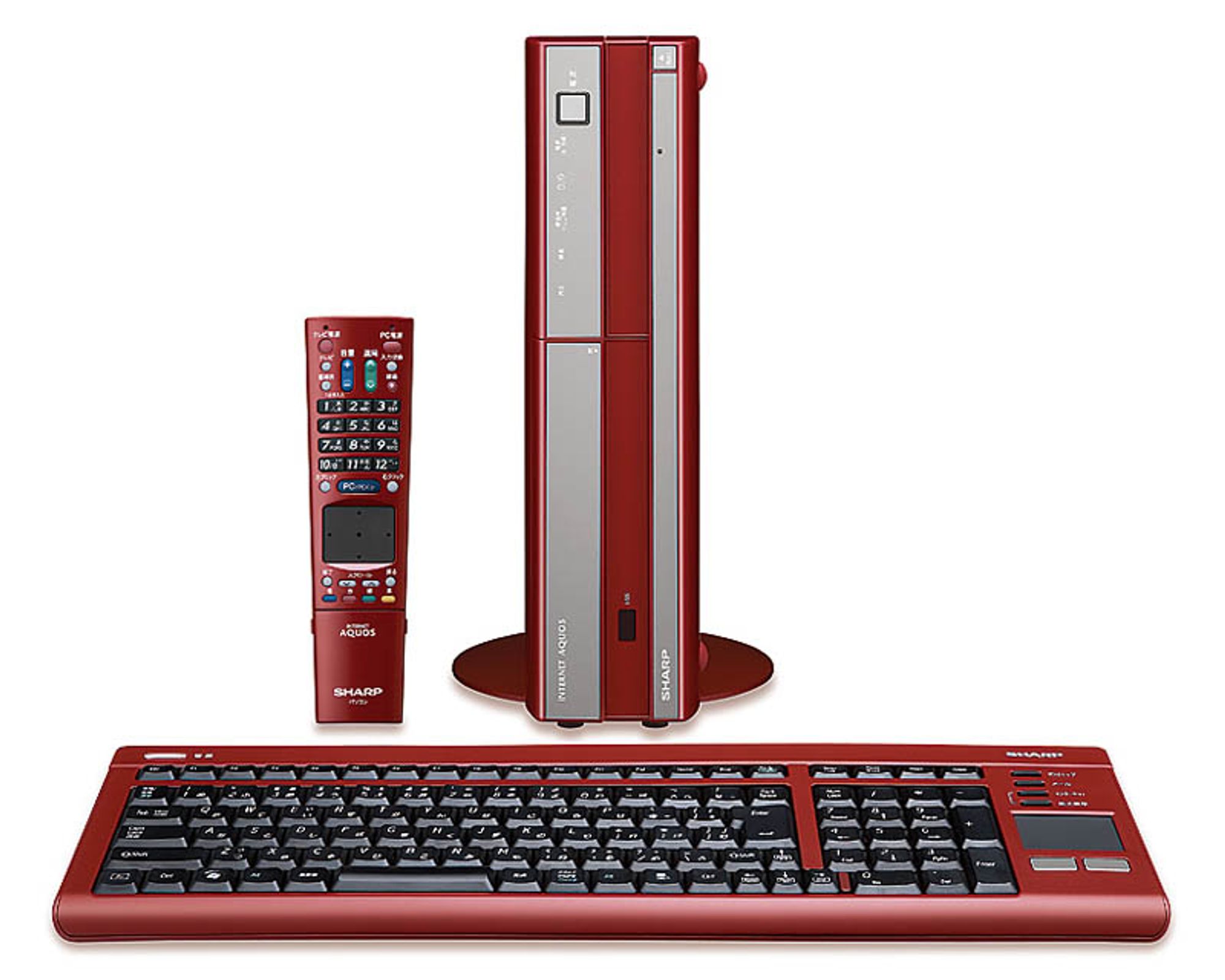 A three-component computer setup, all in the matte red that made Sharp's comptuers distrinct.  Top left, a remote, with volume, chancel changers, keypad, trackpad, mouse buttons, and function buttons; there's a battery hatch at the bottom.  Top right, a slimline vertical tower with a round base, labeled 'INTERNET AQUOS'; there are media control buttons, a power button, a vertical DVD hatch, and a power light.  Bottom, a slimline PC keybaord; the full set of usual IBM keys is present, but the case is scrunched to fit the arrow keys between the tenkey and the keyboard, and the usual navigation keys are presented in a slim strip, in order to fit in one last column of multimedia keys and a two-button trackpad on the right hand side.