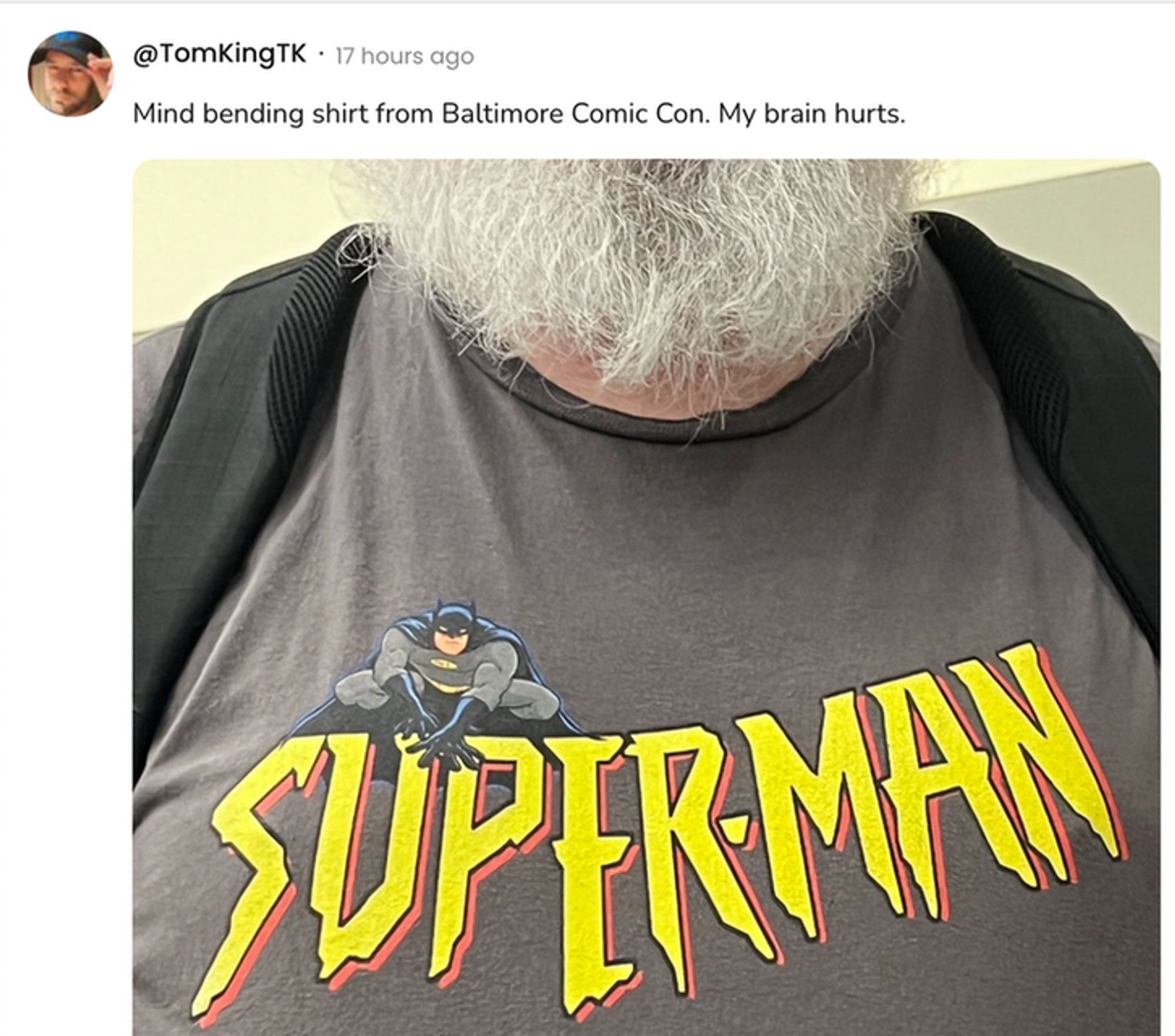  A social post from @TomKingTK that says: Mind bending shirt from Baltimore Comic Con. My brain hurts. [A shirt that says SUPERMAN in the wrong font with an illustration of Batman.]