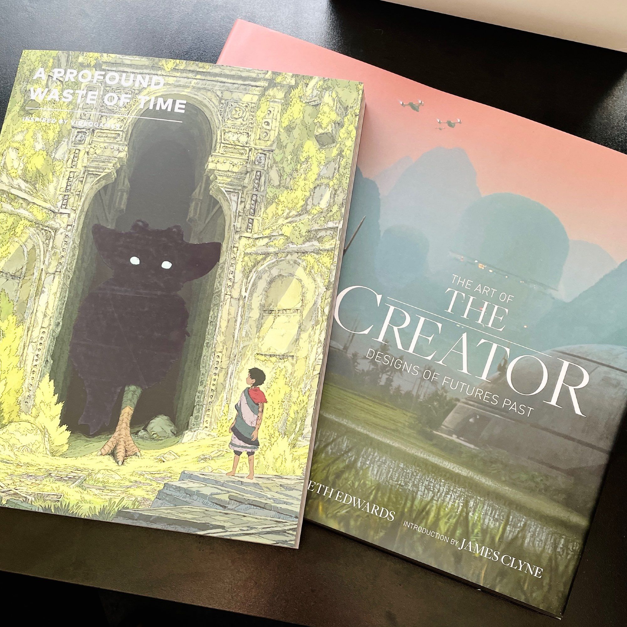 A photo of two books on my desk. The Art of The Creator (concept art from the movie) and A Profound Waste of Time (a lovely magazine about video games).