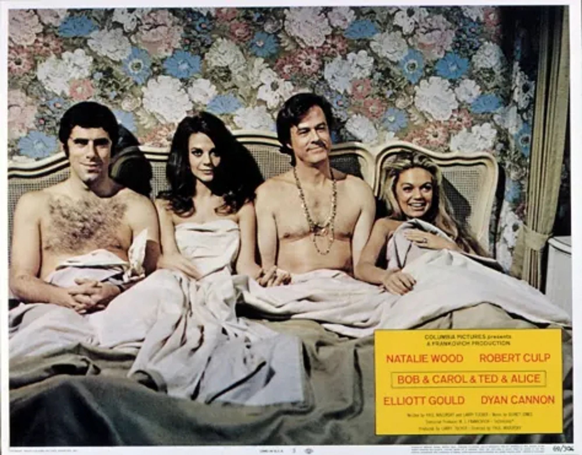 Poster for Bob & Carol & Ted & Alice with Elliot Gould, Natalie Wood, Robert Culp, and Dyan Cannon lined up, sitting up in a single bed and smiling, covered in a sheet.