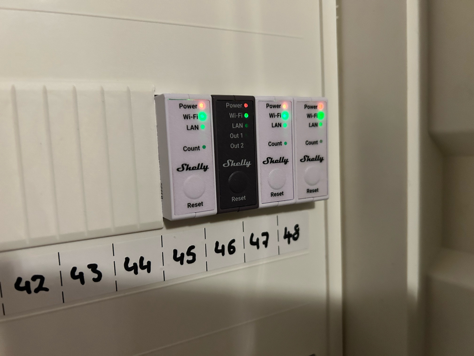 Drei Shelly Pro EM smarte Stromzähler für Hutschienenmontage in einem Schaltkasten, dazwischen noch ein Shelly Pro 2 Smart Relais (dunkelgrau) zur Ansteuerung der „SG Ready“- Schnittstelle (SG=Smart Grid) der Wärmepumpe