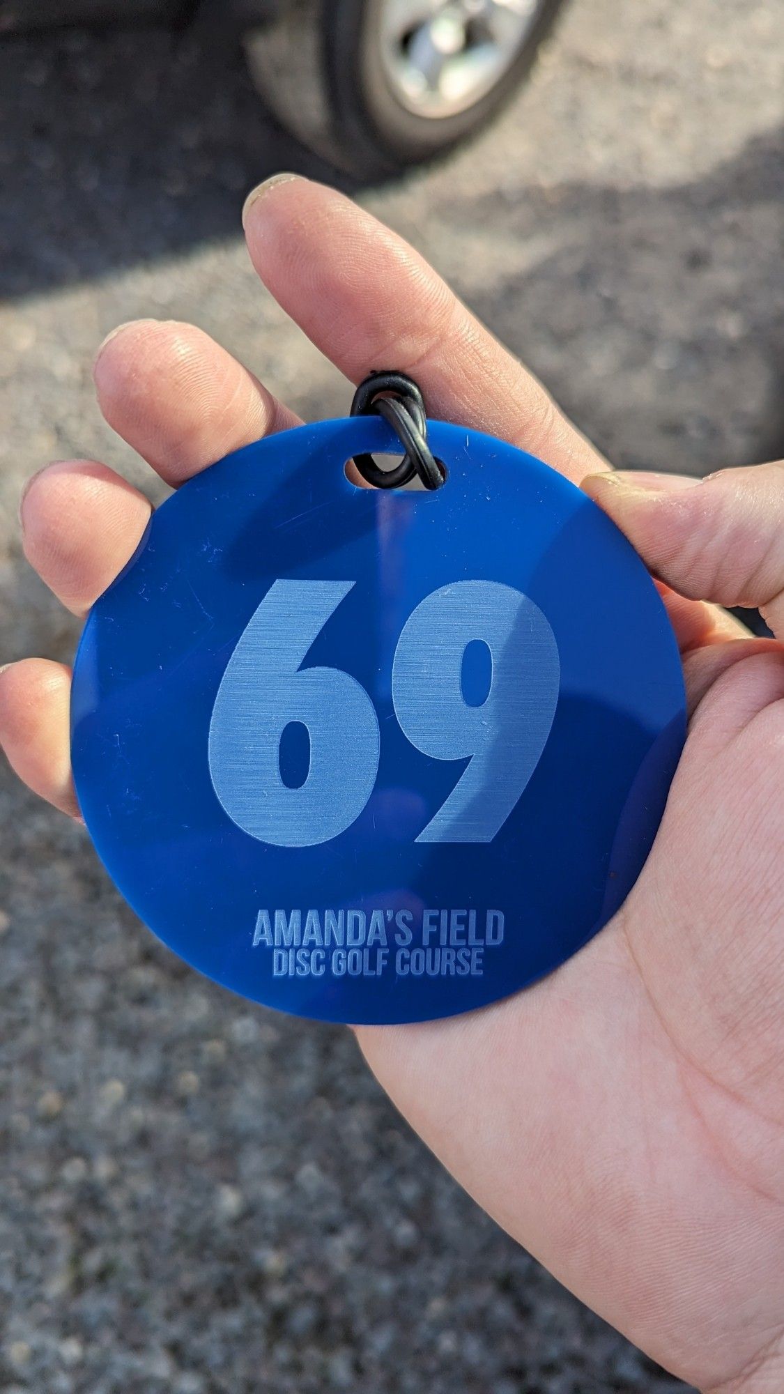 Tag for disc golf that is numbered 69. Tags are a representation of finish position to the rest of the field.