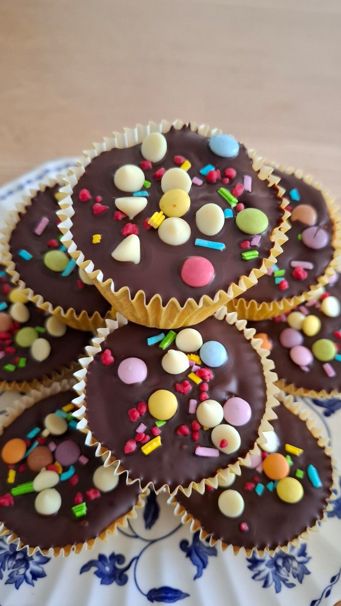 Close up of orange buns topped with chocolate rainbow drops baked by @alexbobsleigh.bsky.social