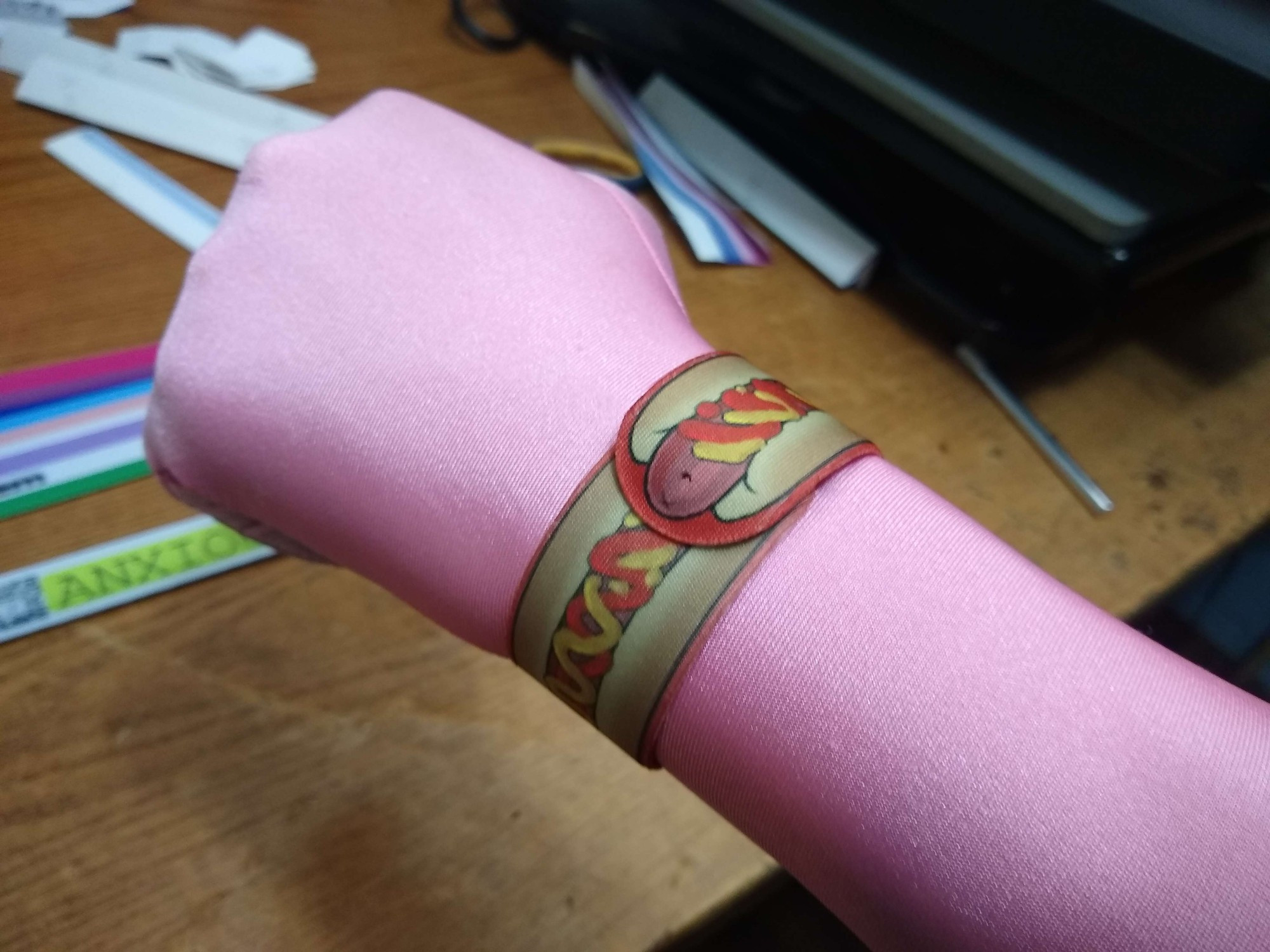 A Hotdog Slap bracelet on a wrist.