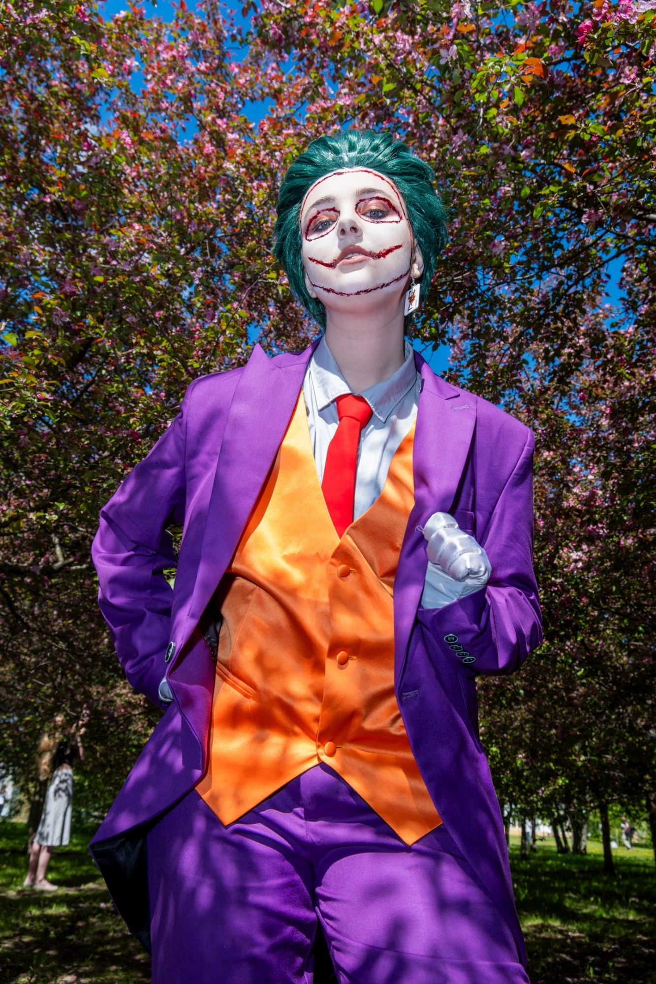 Jay as Joker looking down at the camera in front of blossoming nature