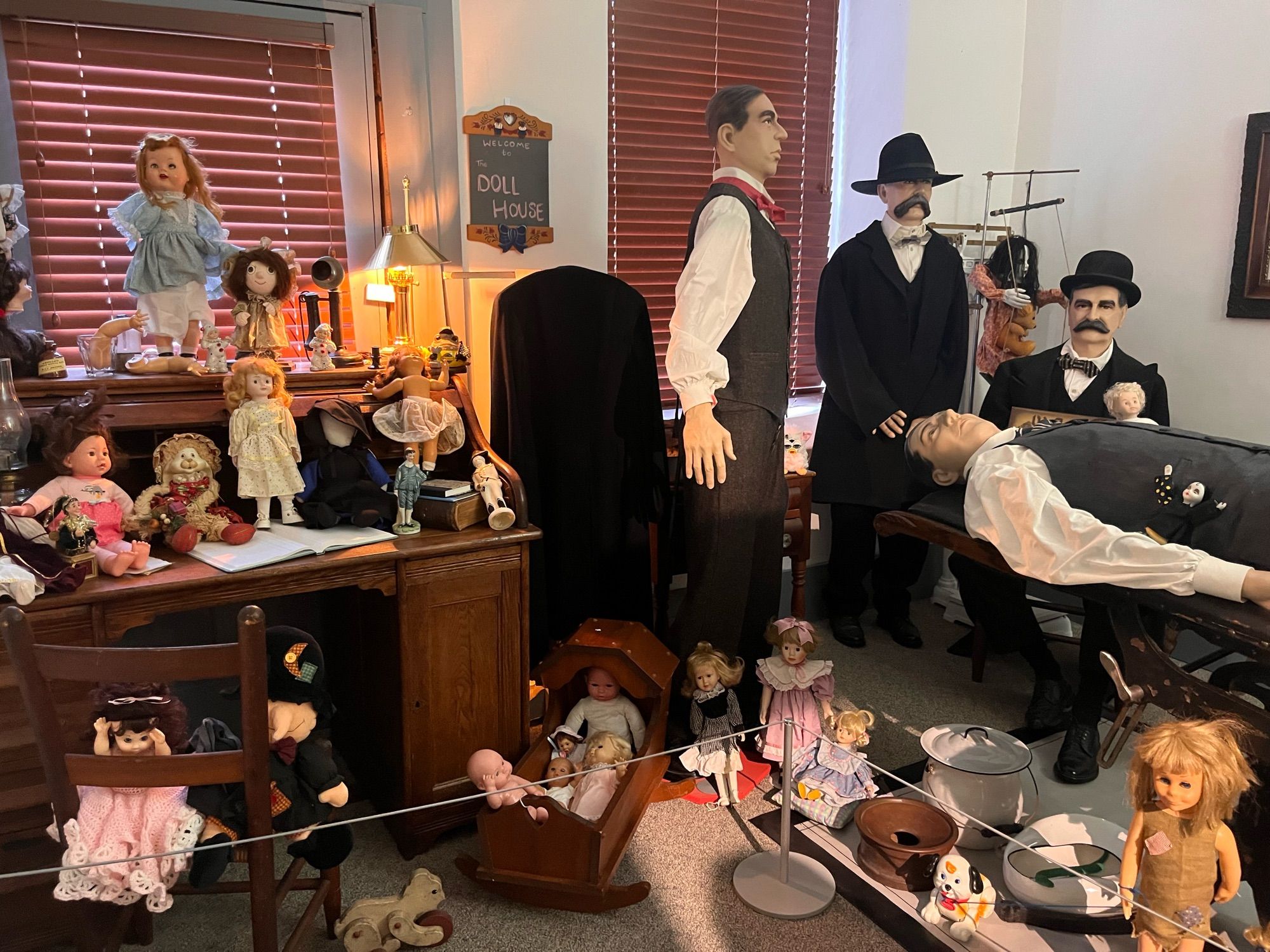 Life size diorama of Governor Goebel receiving medical care after being shot. Room is filled with dolls in every available space.