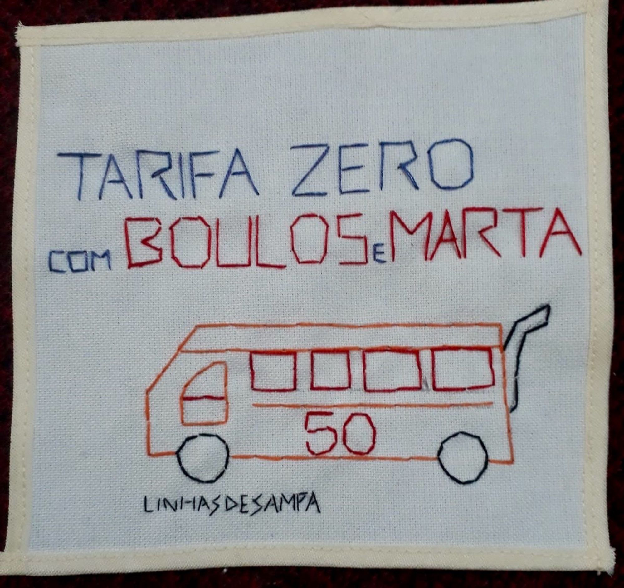 Bordado sobre quadrado de tecido claro com desenho de um ônibus com o número 50 na lateral e os dizeres “Tarifa zero com Boulos e Marta. Embaixo, a assinatura Linhas de Sampa