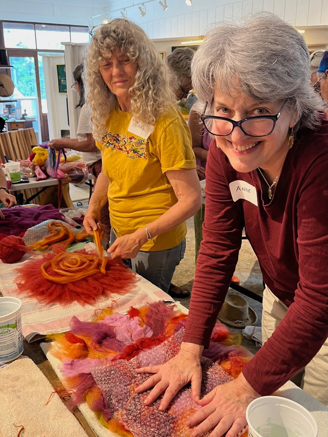 Two workshop participants lock the wool fibers of their felted suns.
