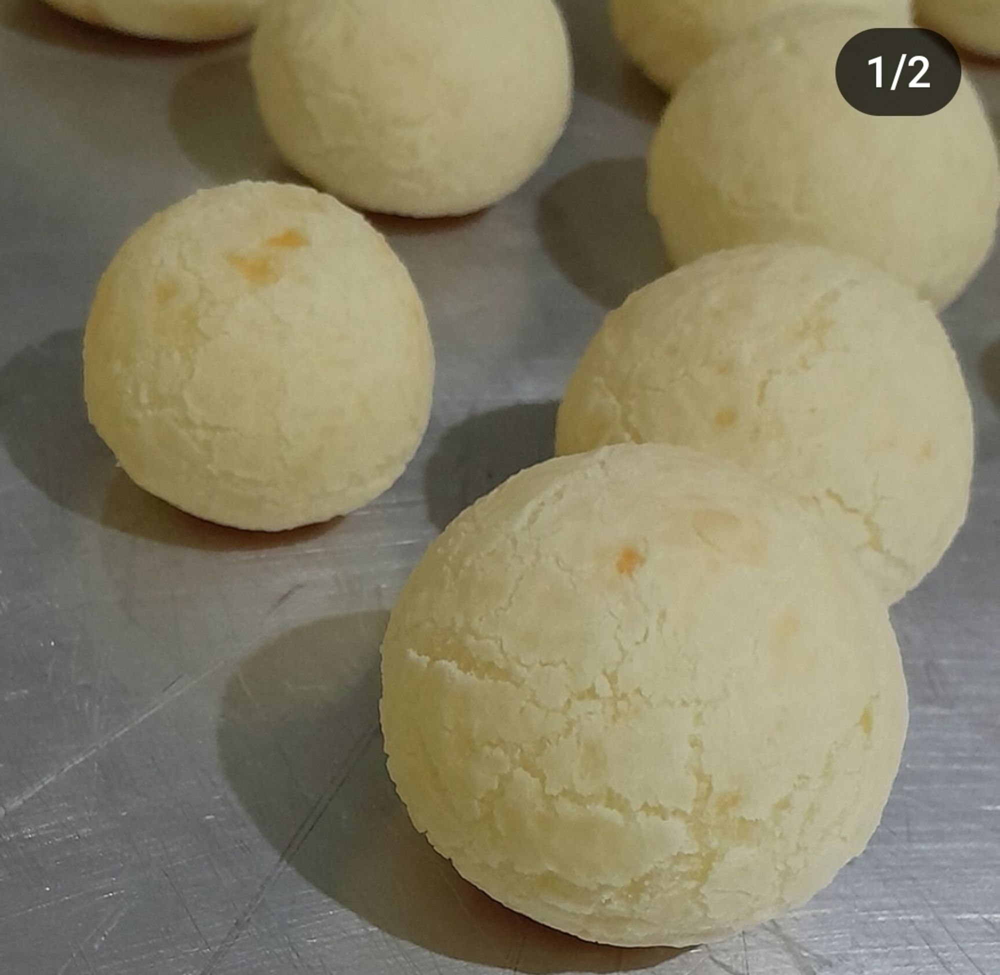 Tabuleiro com vários pães de queijo caseiros.