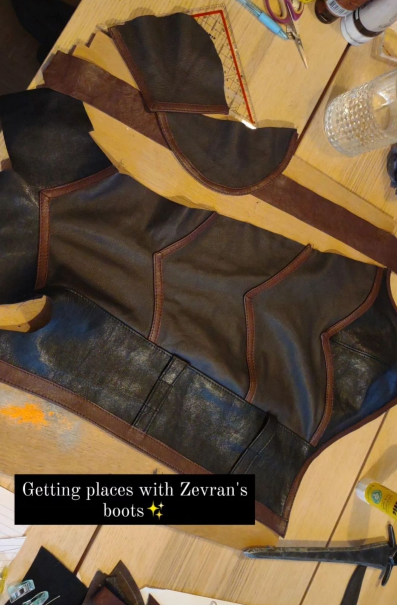 Text: "getting places with Zevran's boots✨" Partially assembled pieces of the leather boots on a table