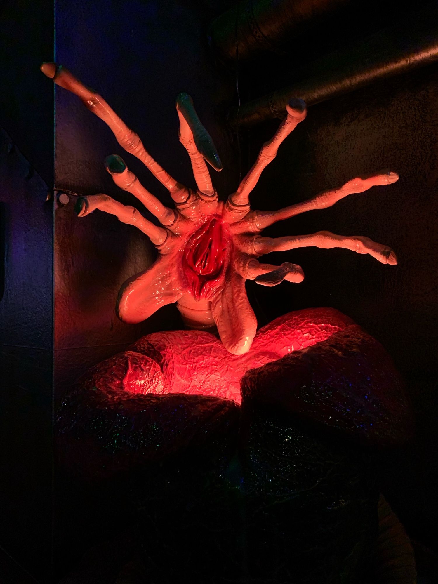 A menacing facehugger from the alien movie, poised to strike, coiled around its egg.