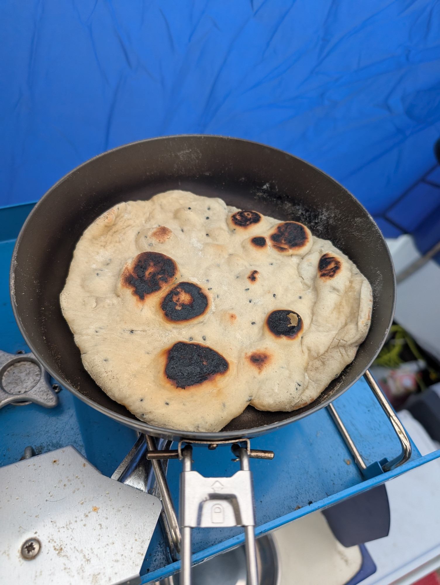 A naan bread cooking in a pan