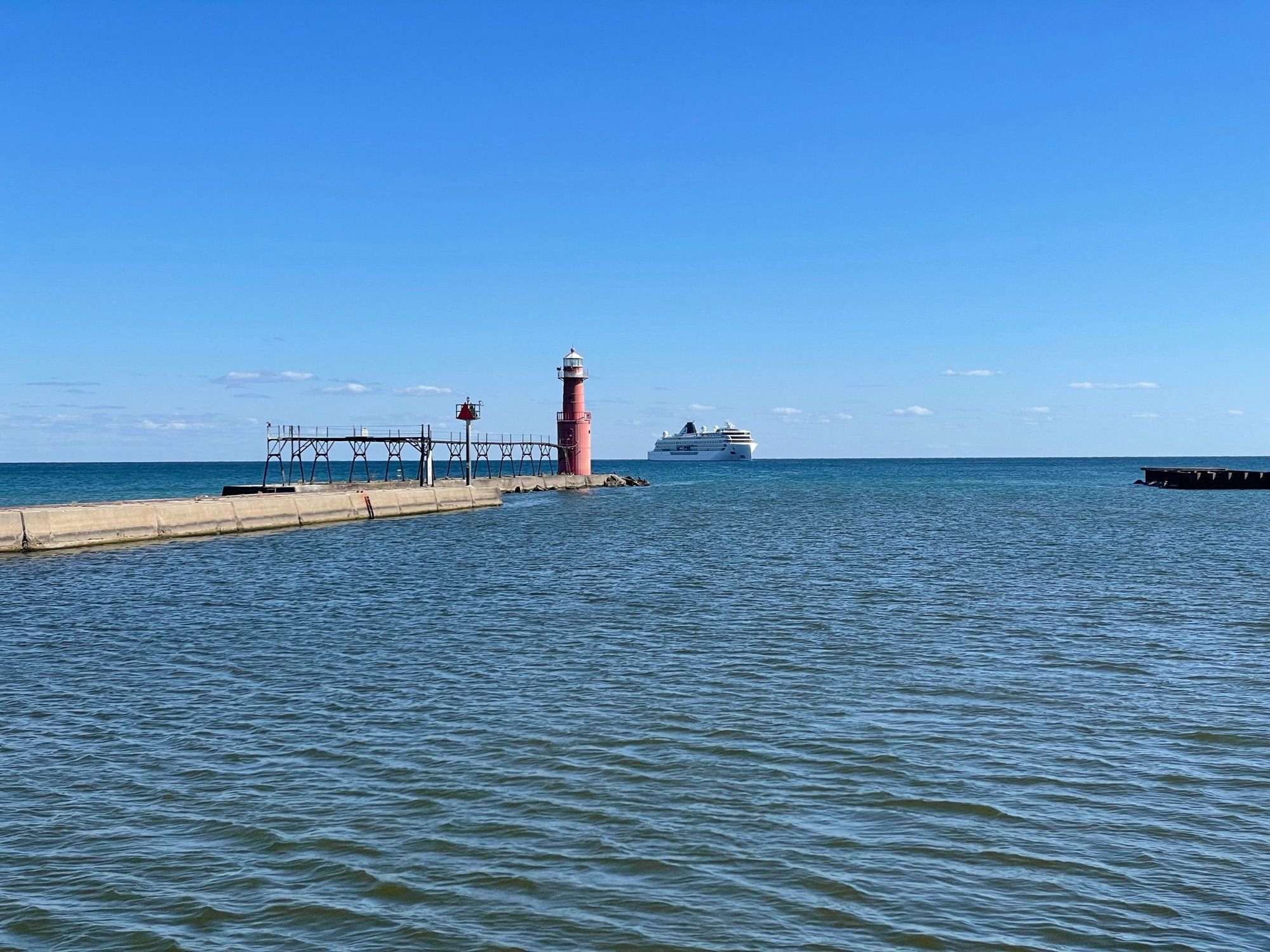 Lighthouse and breakwater at Algoma, Wisconsin with cruise ship in Lake Michigan beyond