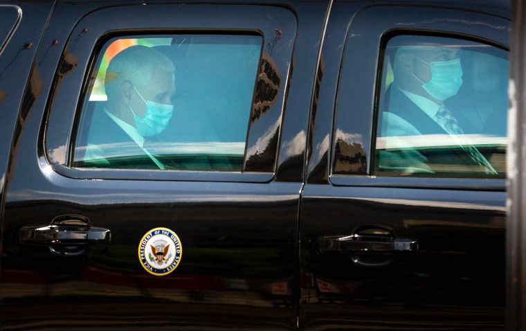 Pence in the back of a limo in a mask