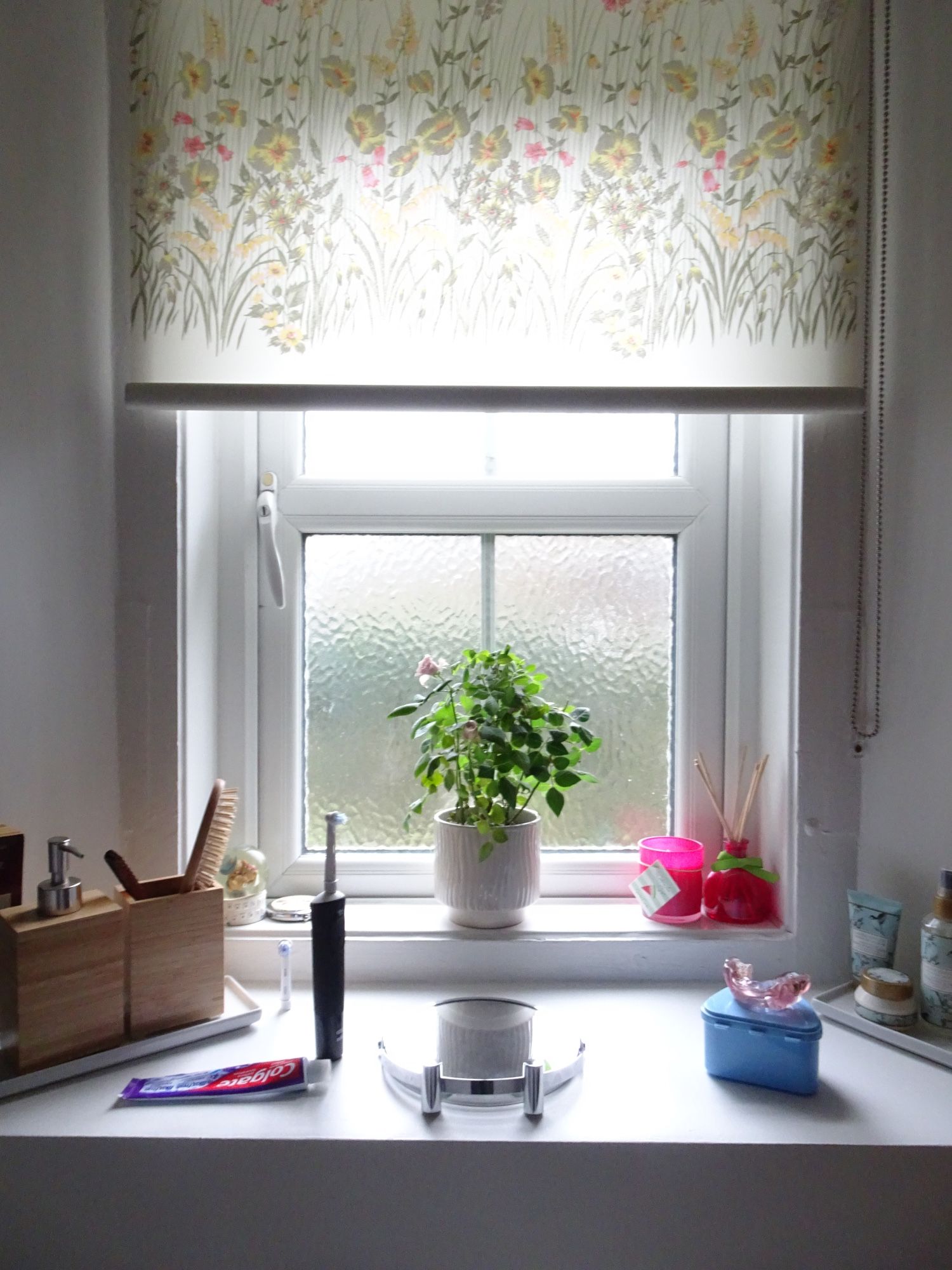 Bathroom window with miniature rose and doodads. This is for the guest’s use.