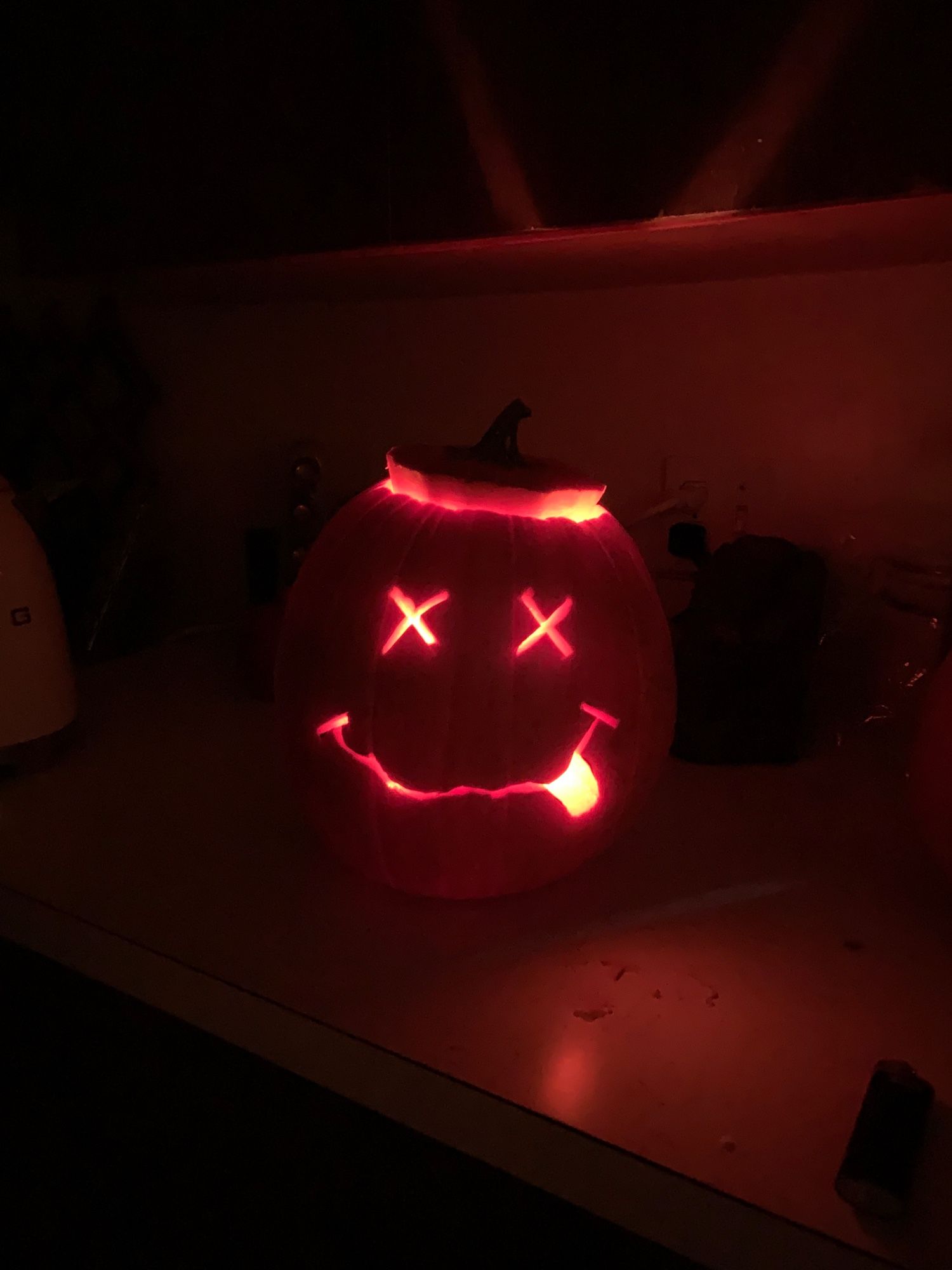 A lit-up jack-o’-lantern carved to look like Nirvana’s classic smiley face with X’s for eyes, a squiggly smile and tongue sticking out on the side