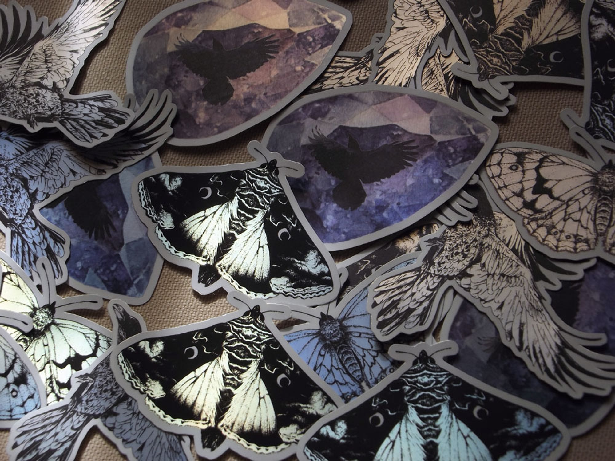 several holographic stickers: butterflies and crows.