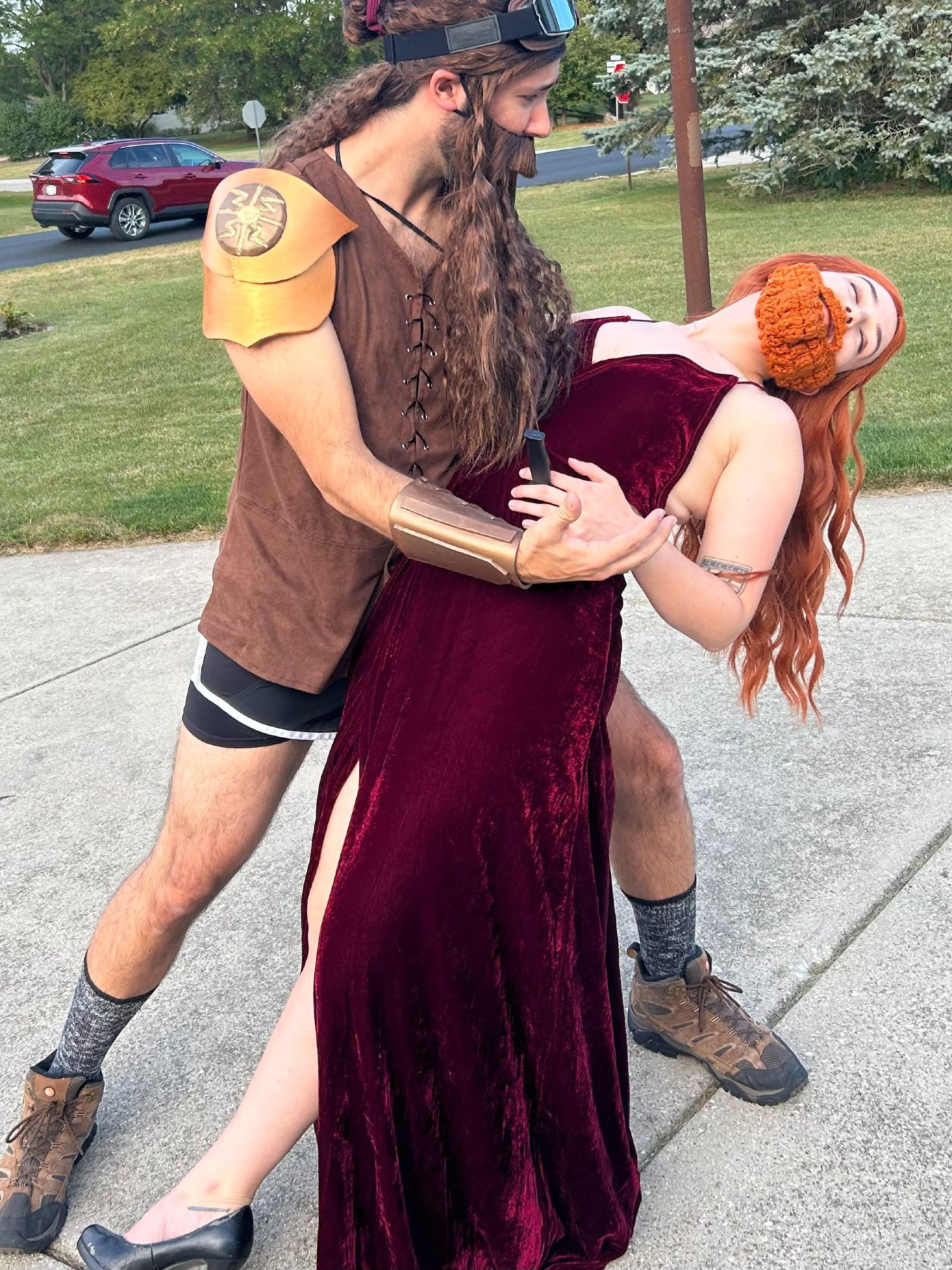 Danny, dressed as Hardwon, and Claire, dressed as Gemma Bronzebeard from NADDPOD embrace in a dip. Claire, as Gemma,'s eyes are closed with a fake dagger in her abdomen. 