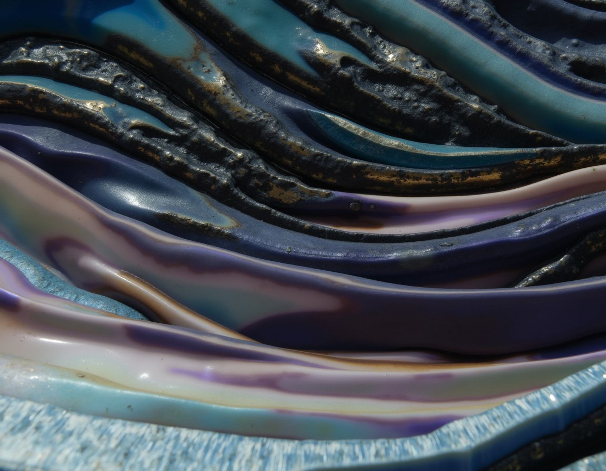 Metamorphic formations in glossy waves and layers, in teals, blues, and purples, juxtaposing smooth and rough textures.