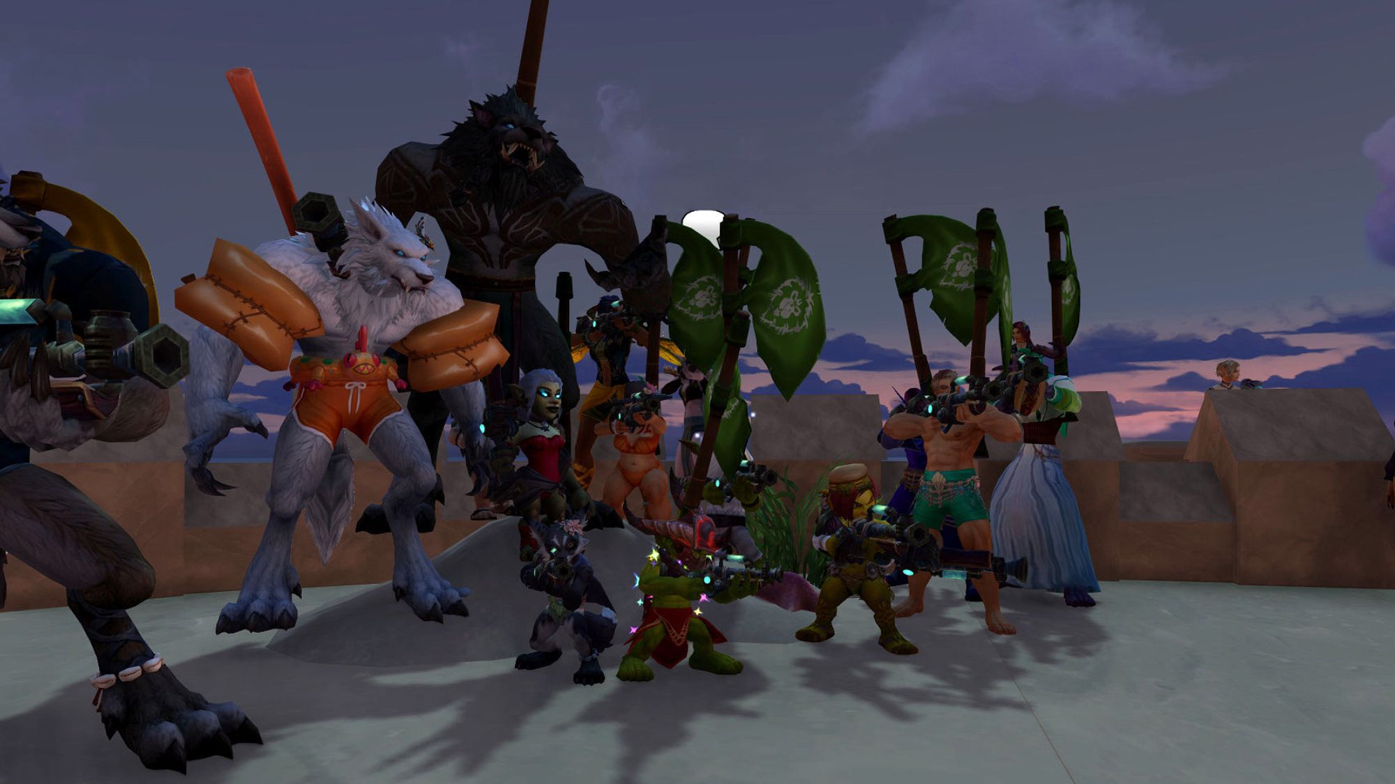 A Warcraft screenshot of several characters, including a black furred vulpera, several worgen and goblins, and a few elves, standing on the surface of a life sized sandcastle, all wielding water guns and in various states of beachwear. Many of them bear green flags.