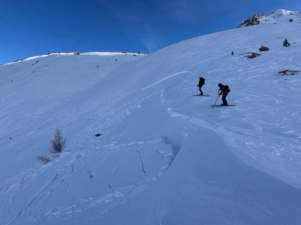 Zwei Tourenskifahrer in einem schattigen Nordosthang oberhalb einer Lawinenabrisskante  /  📷️ C. Lucas, 2300 Nordost, Münstertal GR