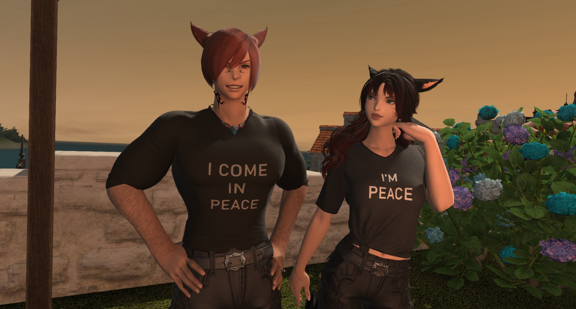 G’raha is wearing a t-shirt that reads ‘I Come In Peace’ and standing proudly. K’yalwenn is beside him, looking at him appreciatively and wearing a similar t-shirt that reads ‘I’m Peace’