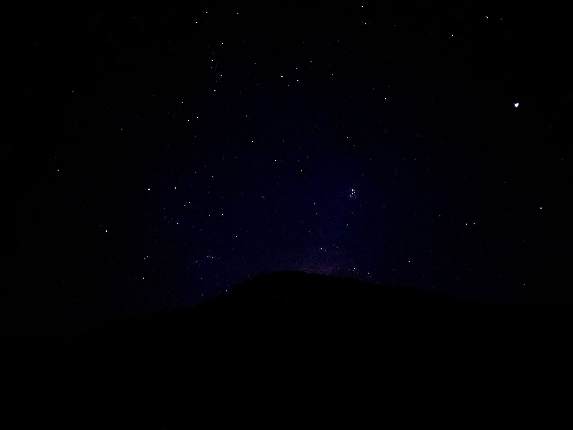 Pléyades, cúmulo estelar abierto, saliendo de la montaña.