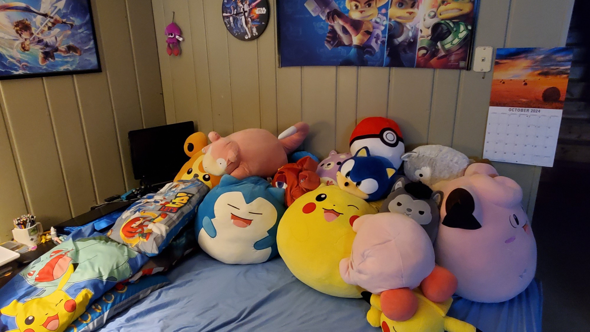 Too many plushes? Probably not. Many pokemon squishmallows, and additional plushes on a bed.