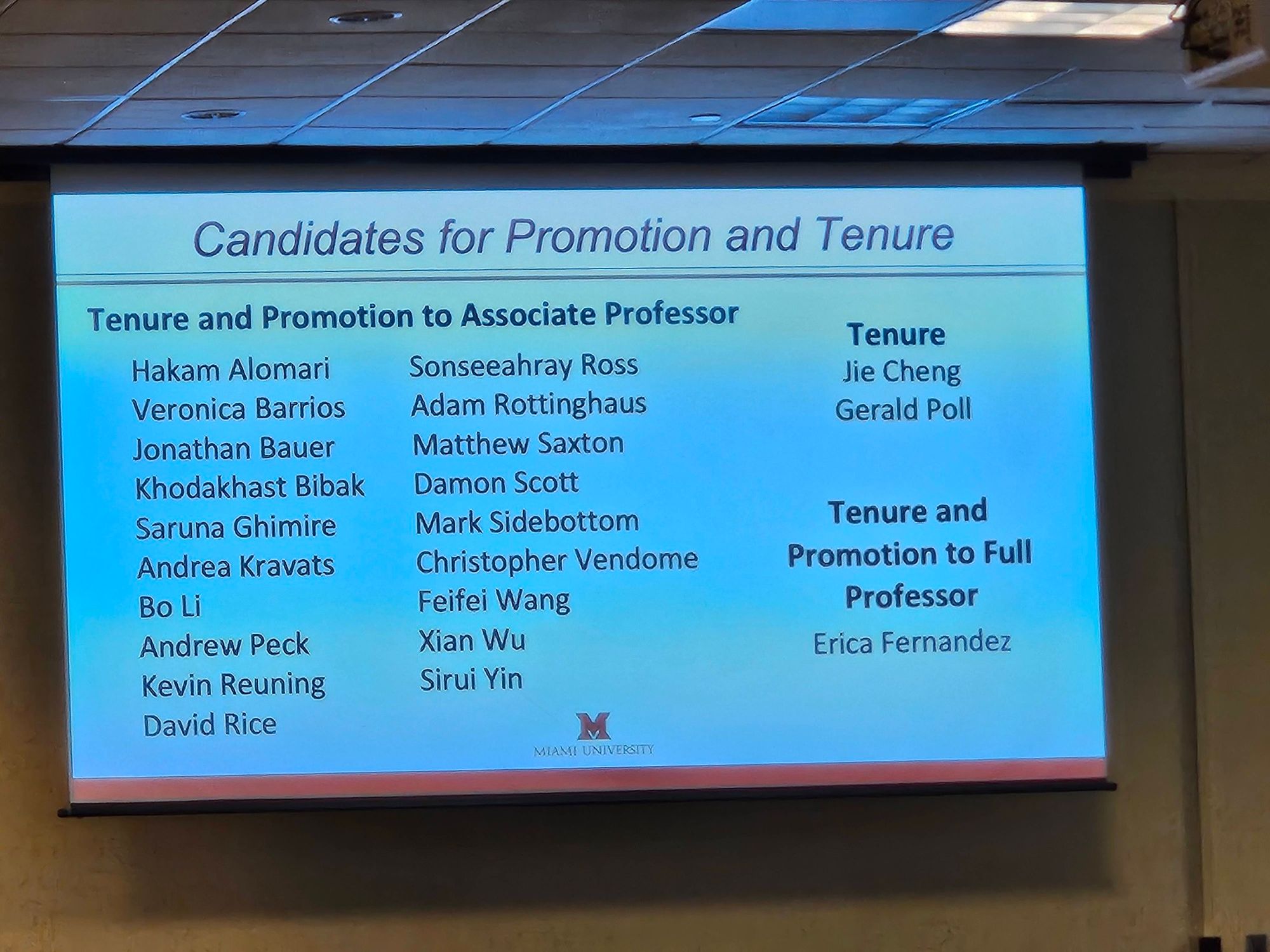 Photo of a slide of showing the list of faculty  being given tenure.