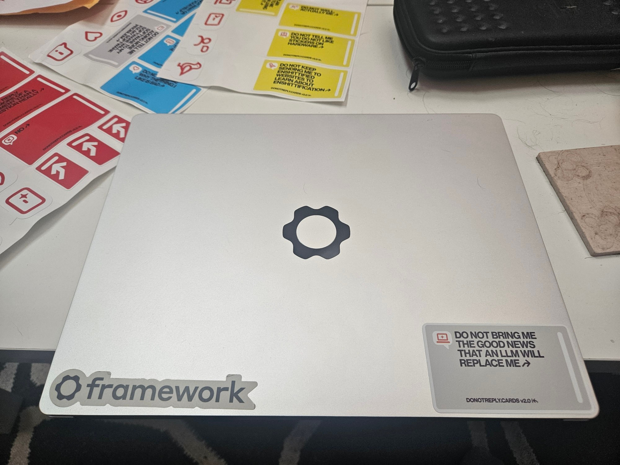 Laptop with a sticker on the bottom right that says "Do not bring me the good news that an LLM will replace me"