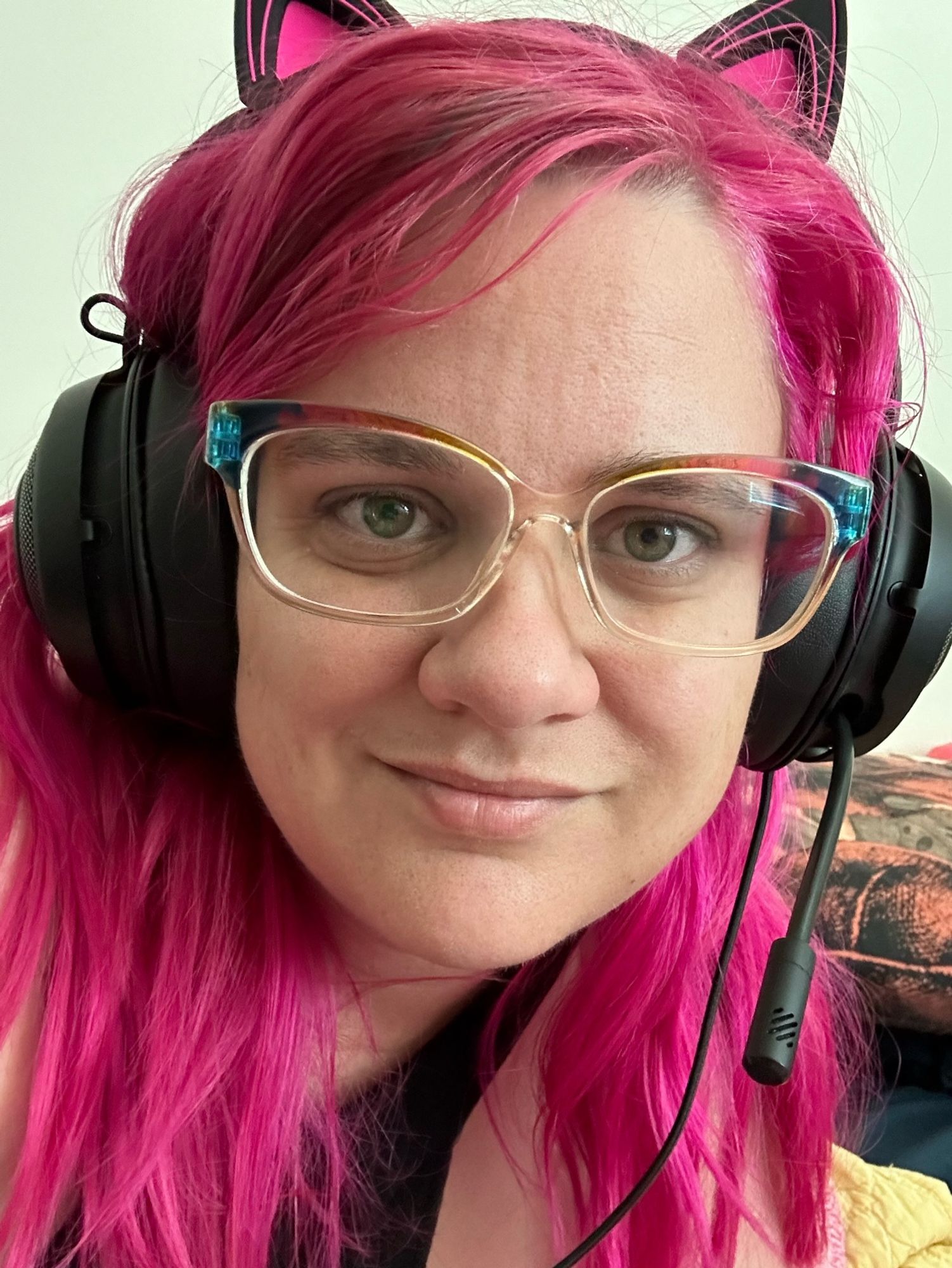 New pink hair with cat ears on headphones, sleepy but smiling