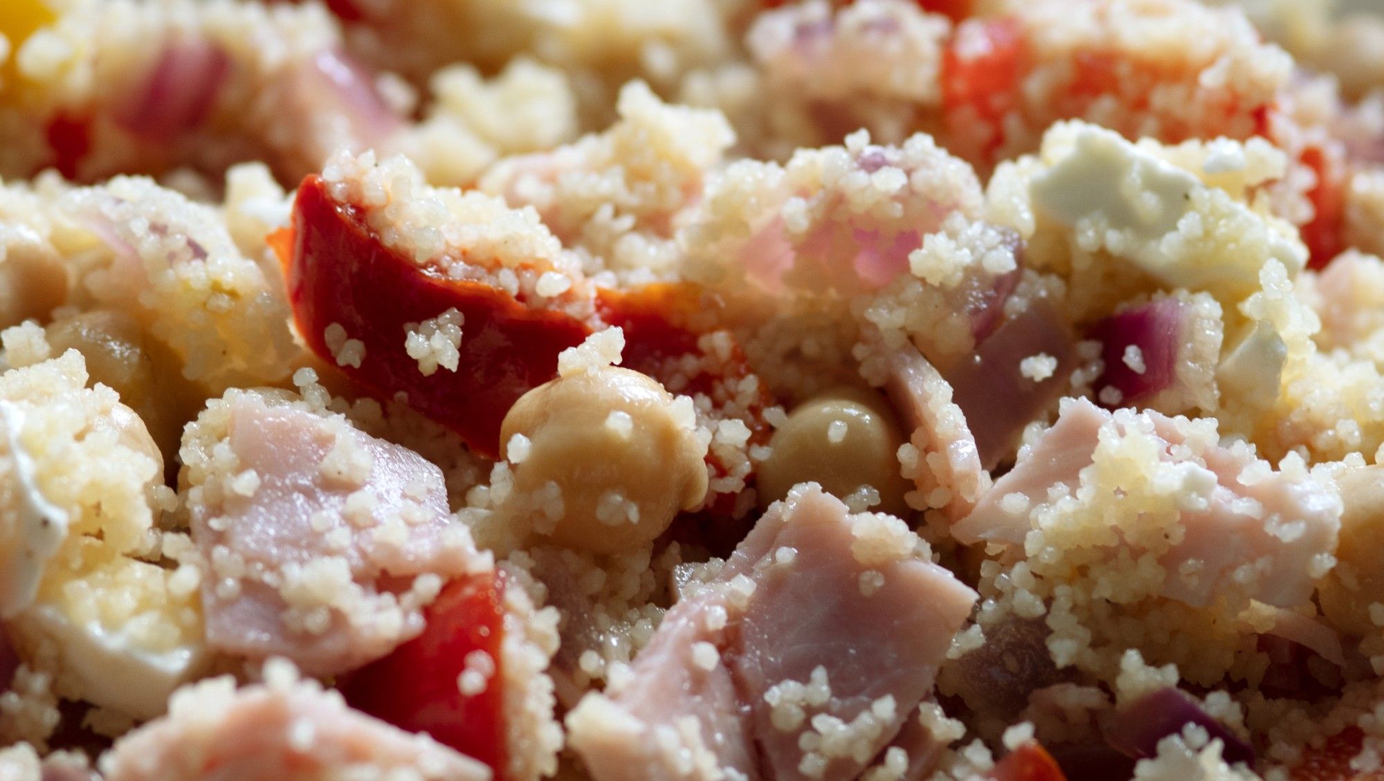 Chunks of ham, red pepper, feta and chickpeas in couscous