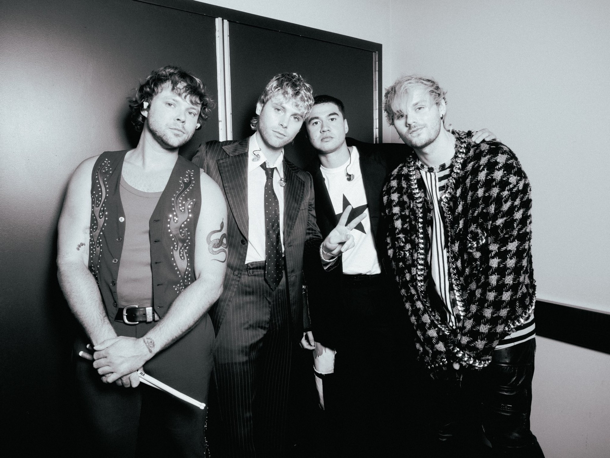 All four members of 5 Seconds of Summer posing next to each other in black and white