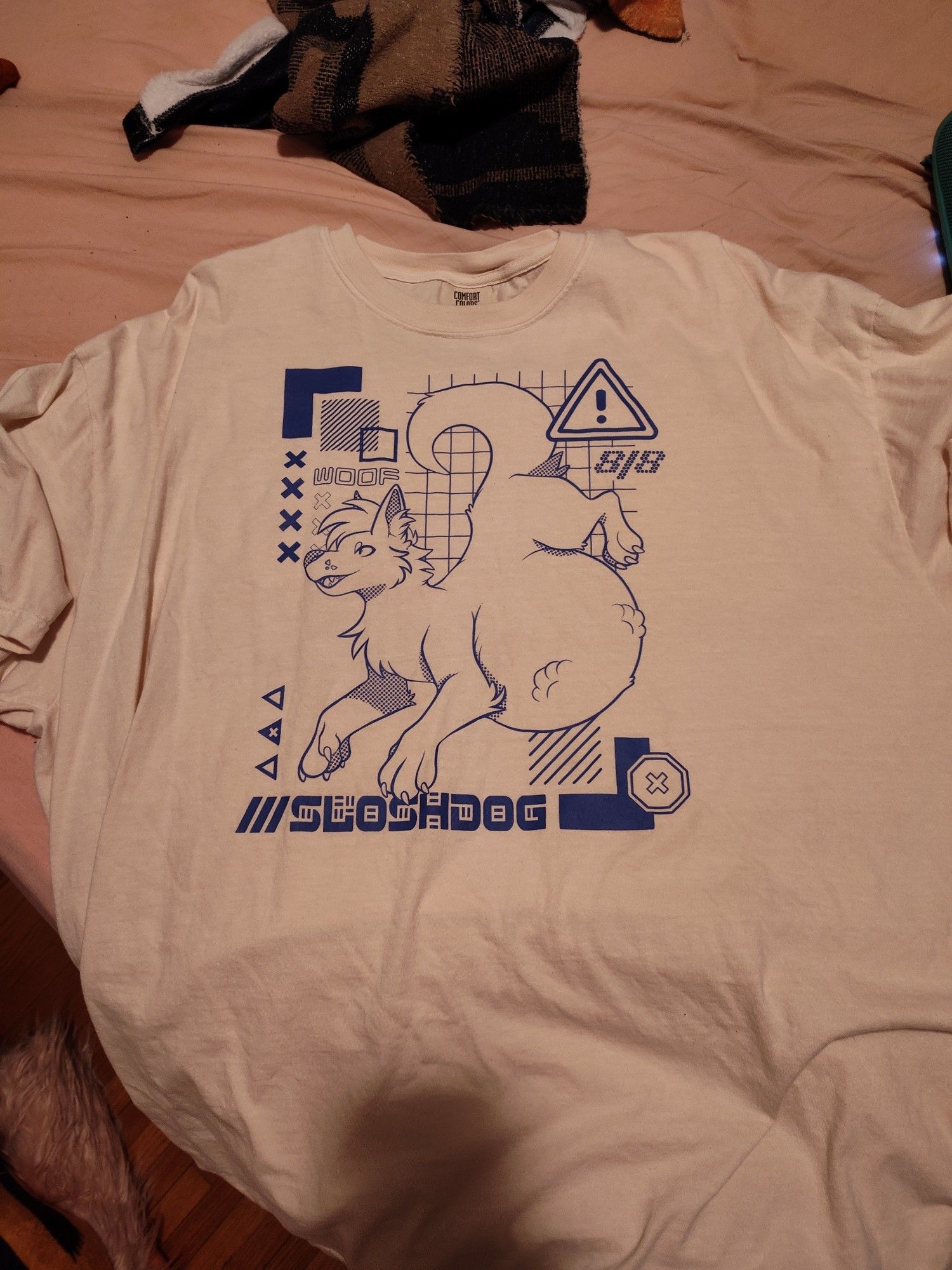 An image of a t-shirt from Sloshdog, a furry brand that specializes in vore-themed clothing. This one is very unsubtle, featuring an image of a dog with a large belly and paw print bulges under it's fur.