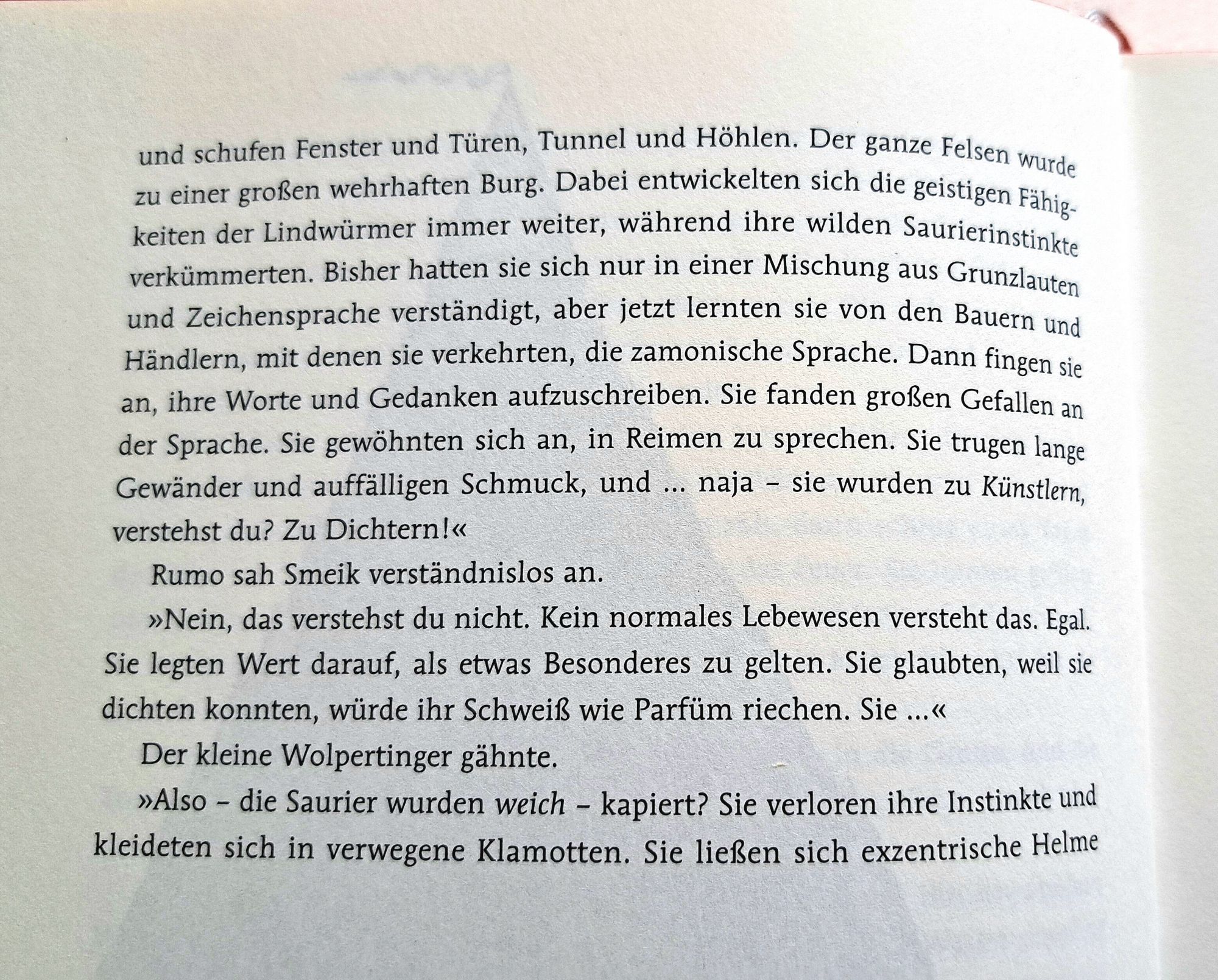 Textkopie aus dem Buch:
Der ganze Felsen wurde zu einer großen wehrhaften Burg. Dabei entwickelten sich
die geistigen Fähigkeiten der Lindwürmer immer weiter, während ihre wilden Saurierinstinkte verkümmerten. Bisher hatten sie sich nur in einer Mischung aus Grunzlauten und Zeichensprache verständigt, aber jetzt lernten sie von den Bauern und
Händlern, mit denen sie verkehrten, die zamonische Sprache. Dann fingen sie
an, ihre Worte und Gedanken aufzuschreiben. Sie fanden großen Gefallen an der Sprache. Sie gewöhnten sich an, in Reimen zu sprechen. Sie trugen lange
Gewänder und auffälligen Schmuck, und .. naja - sie wurden zu Künstlern verstehst du? Zu Dichtern.
Rumo sah Smeik verständnislos an.
Nein, das verstehst du nicht. Kein normales Lebewesen versteht das. Egal.
Sie legten Wert darauf, als etwas Besonderes zu gelten. Sie glaubten, weil sie
dichten, würde ihr Schweiß wie Parfüm riechen. Sie ...
Der kleine Wolpertinger gähnte.
Also - die Saurier wurden weich - kapiert? ...